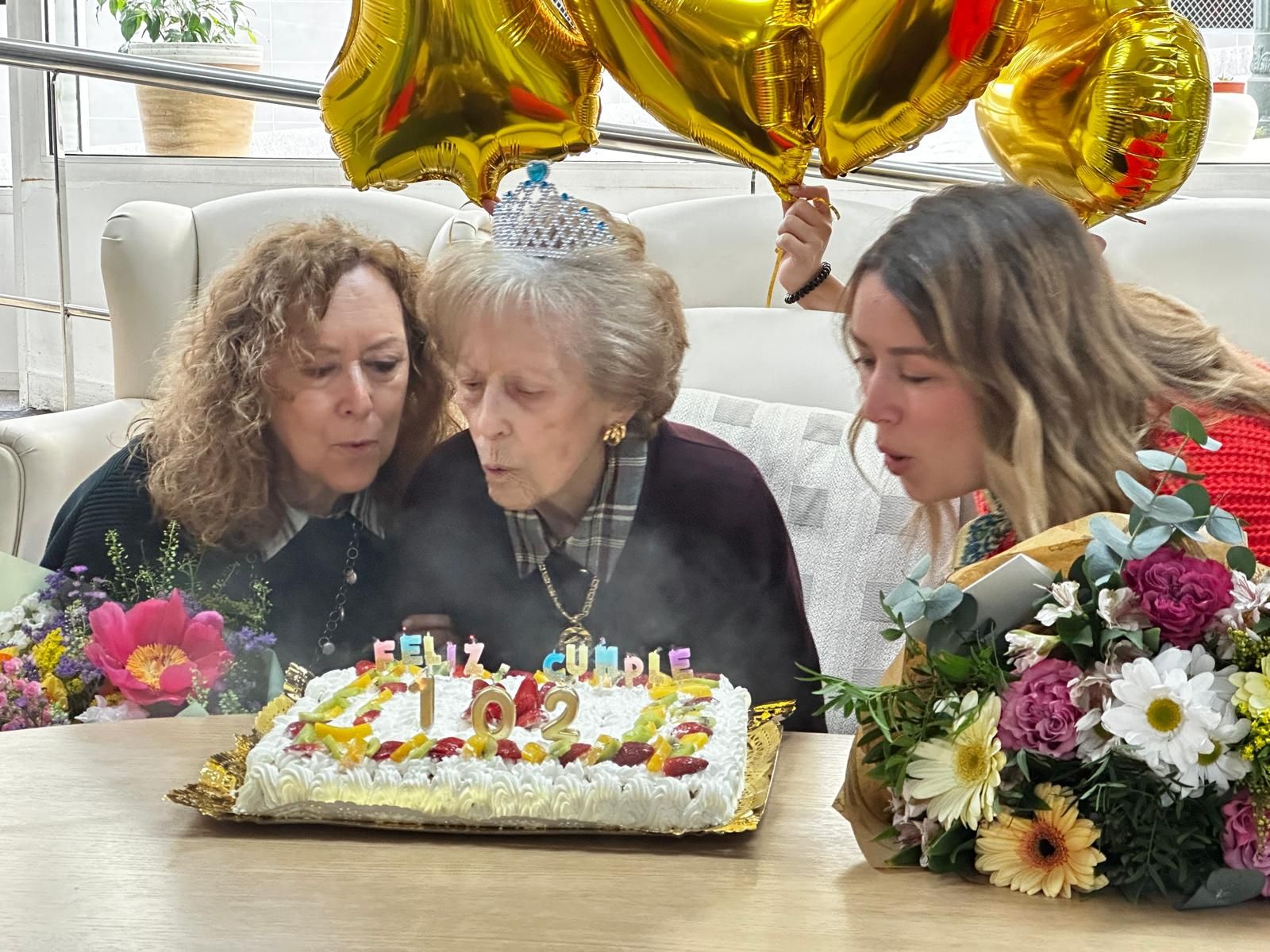Tres generaciones soplando las velas de la abuela Doña Ana