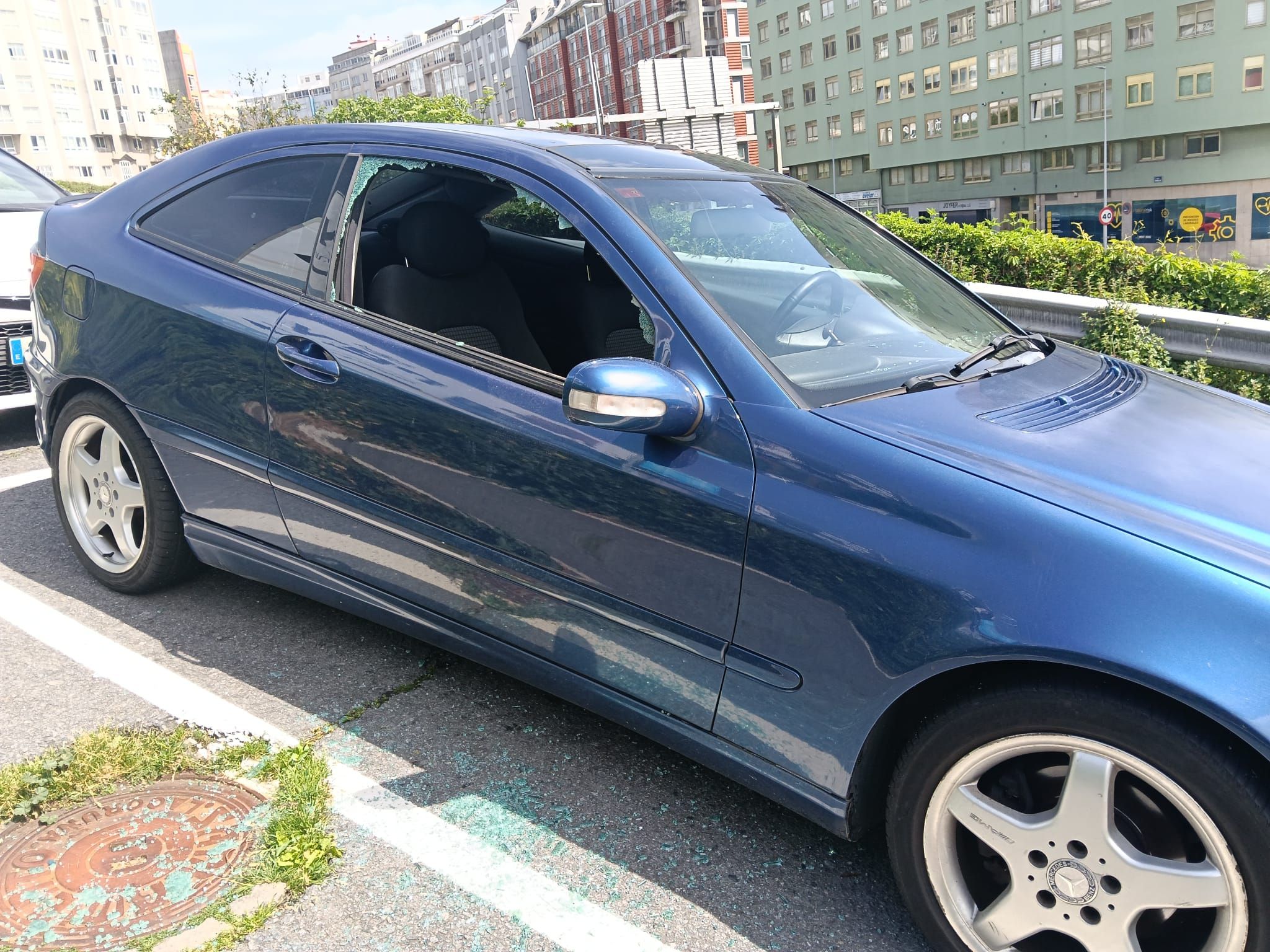 Uno de los vehículos con los cristales rotos en el barrio coruñés de Os Castros