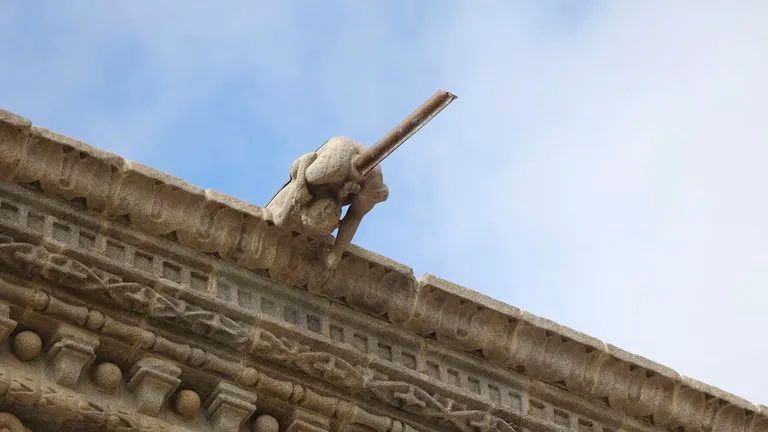 La mayoría de las gárgolas simulan una cara con el tubo saliendo de la boca menos una que reproduce un niño de espaldas agachado