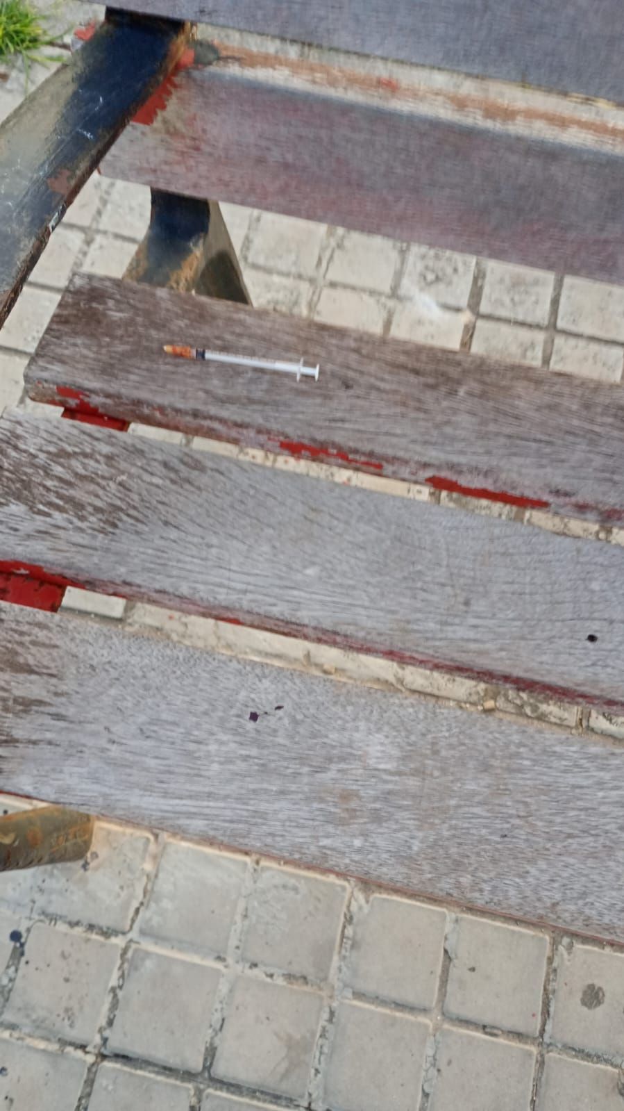 Jeringuilla usada hallada en un banco frente a la puerta del colegio