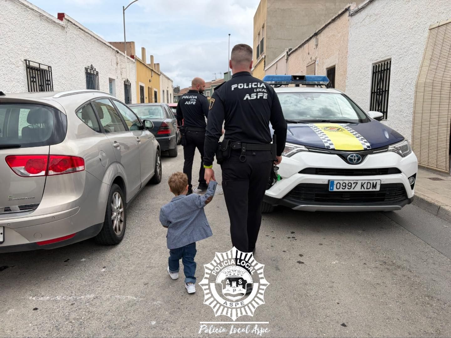El pequeño caminando de la mano de uno de los agentes