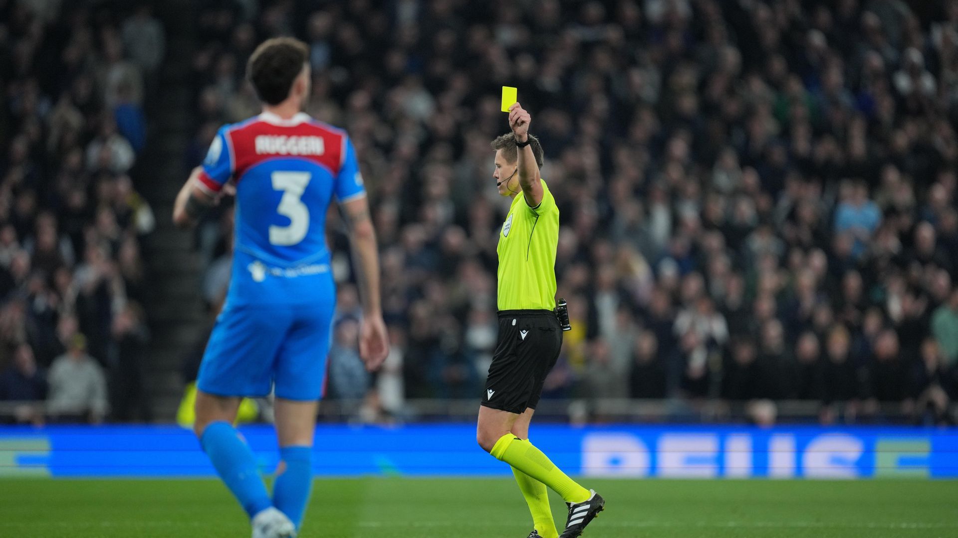 Daniel Siebert mostrando una tarjeta amarilla a Ruggeri