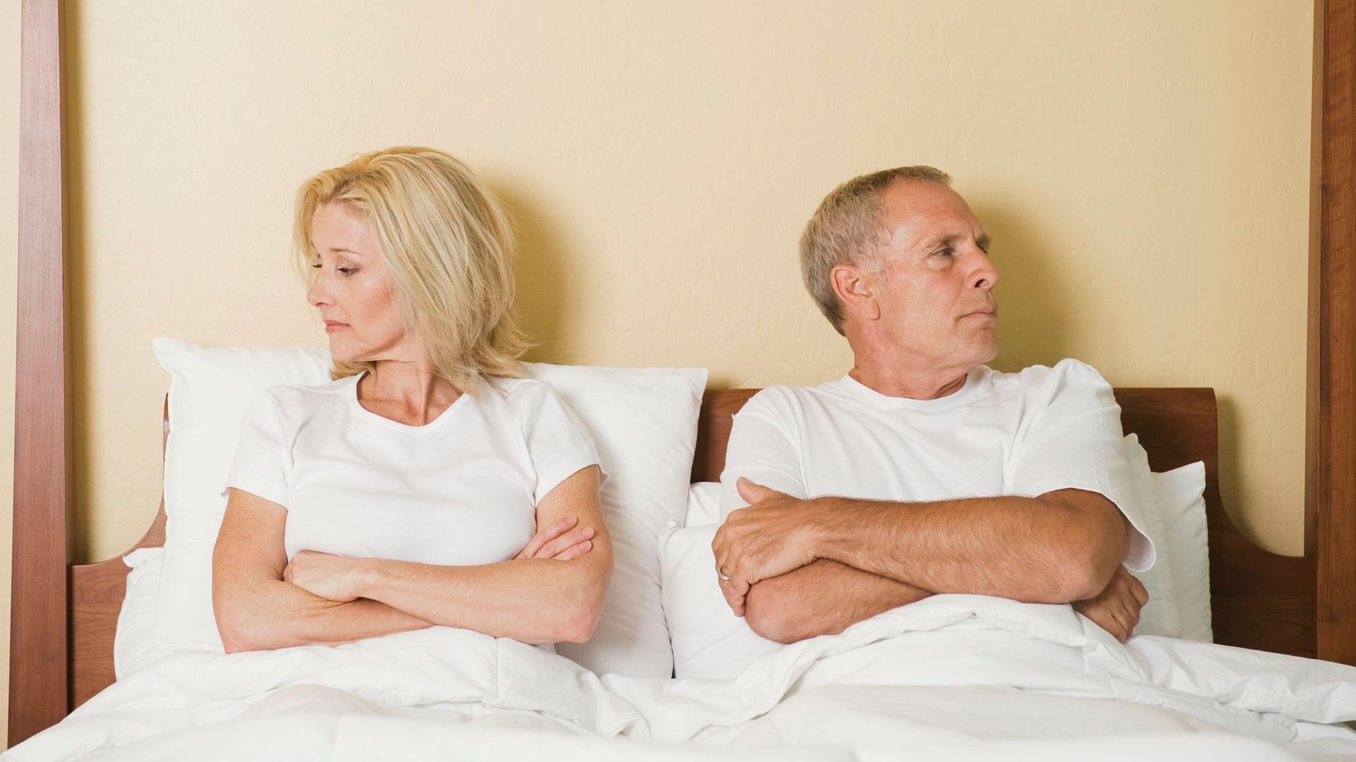 Una pareja, en la cama mira cada uno hacia un lado