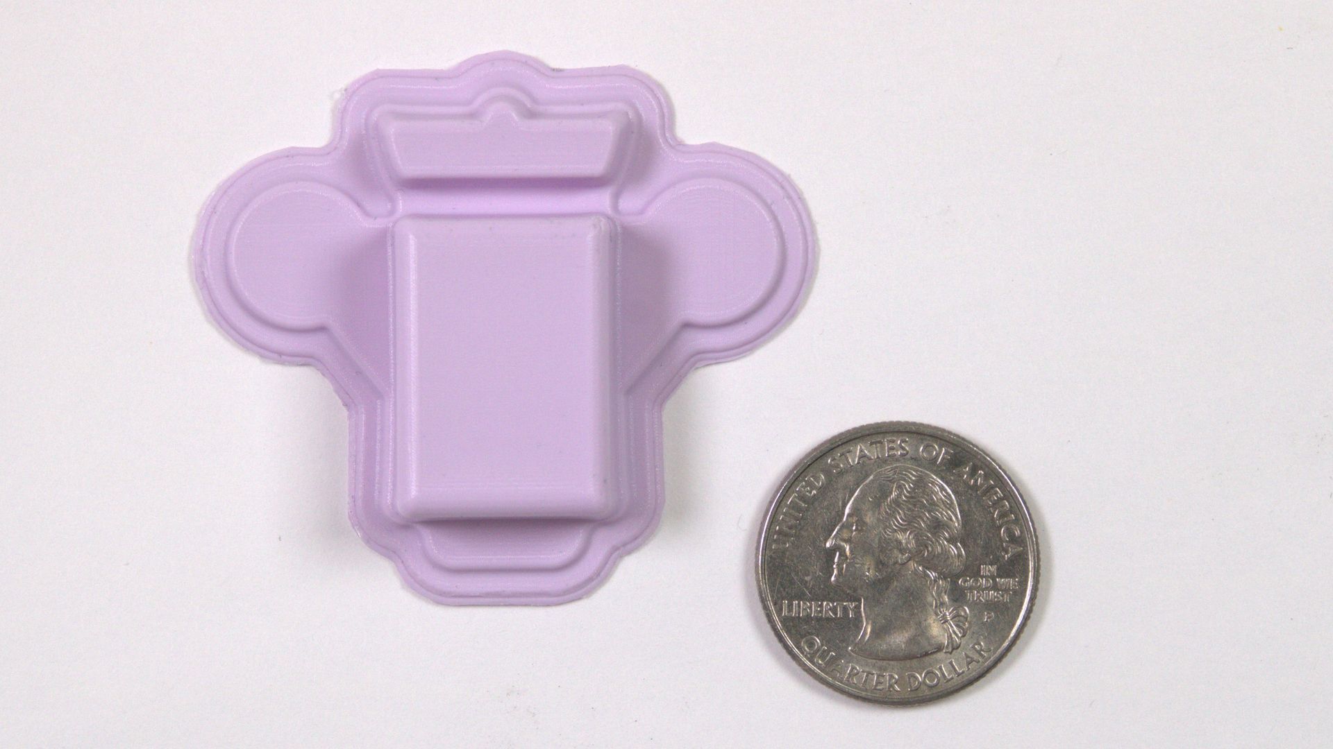 El polígrafo portátil junto a una moneda de veinticinco centavos para comparar el tamaño