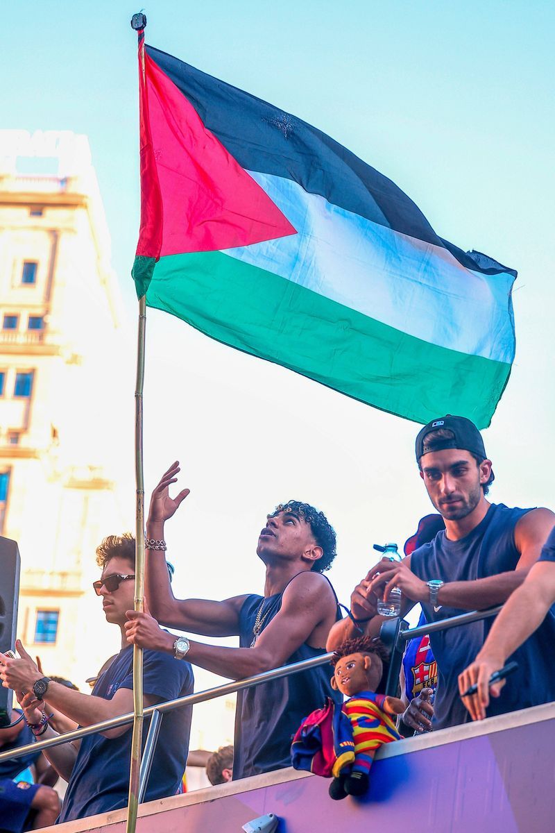 Lamine Yamal, con una bandera de Palestina en la rúa del Barcelona