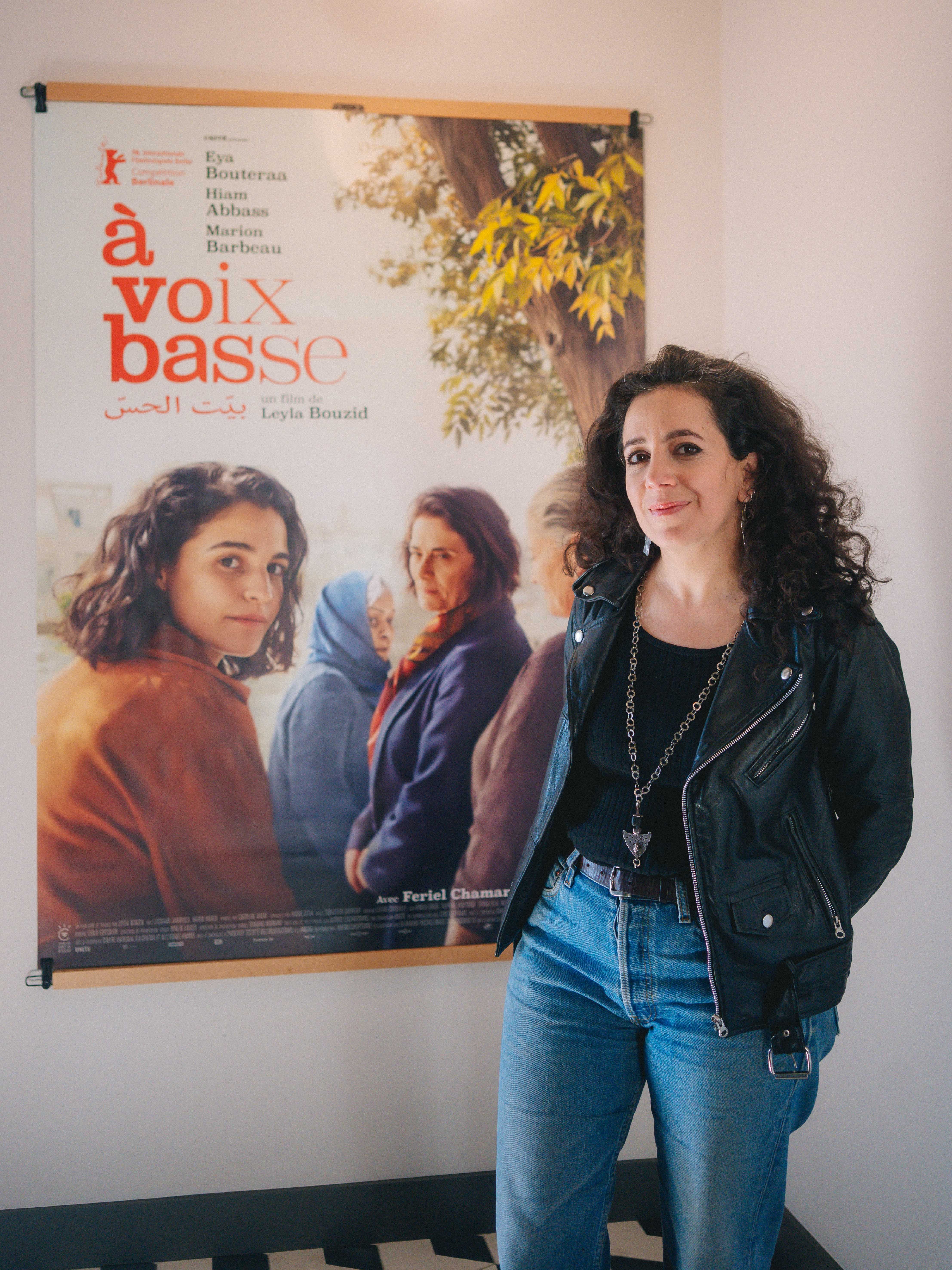 Leyla Bouzid junto al cartel de 'Tres Mujeres', aclamada en Berlín, y que llegará a los cines españoles el próximo 22 de mayo