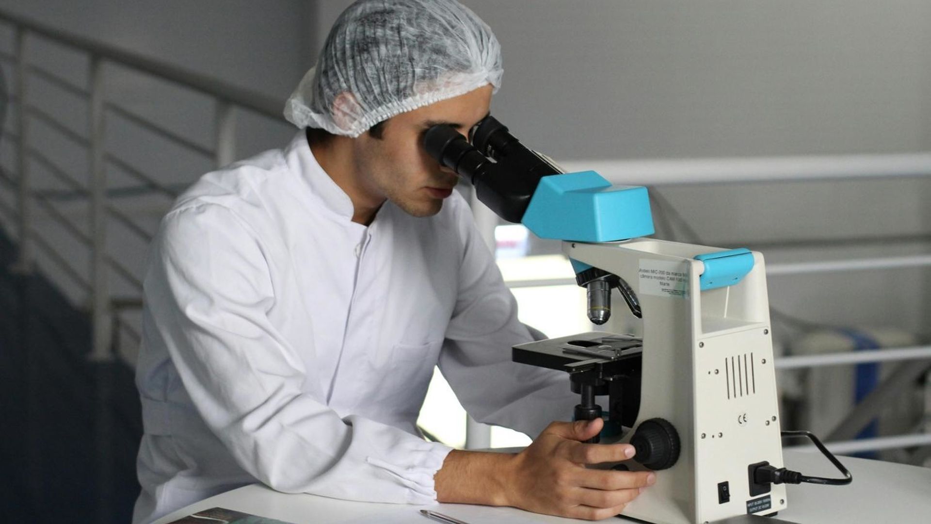 Foto de archivo de un investigador usando un microscopio. Foto de archivo de un investigador usando un microscopio.
