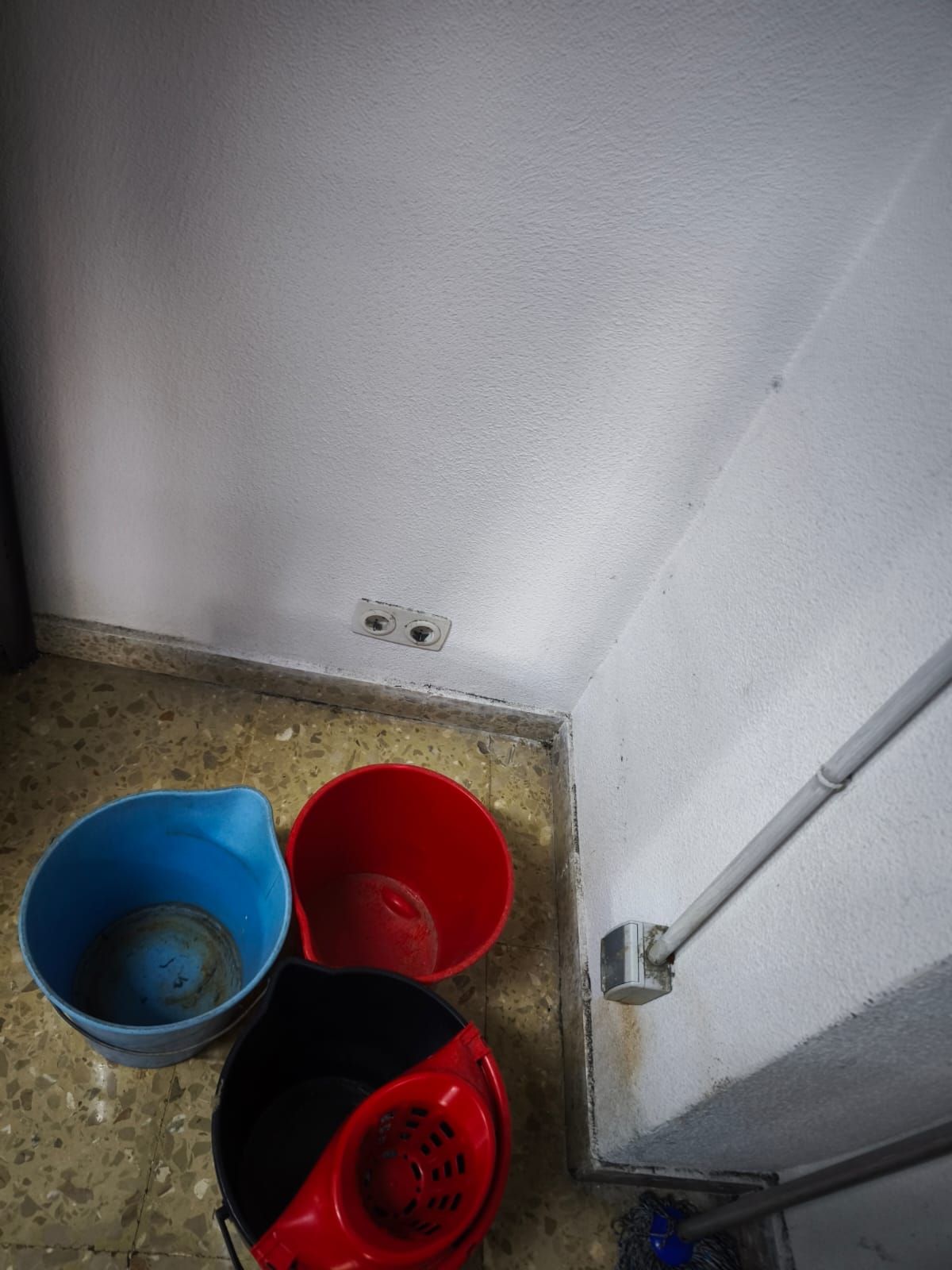 Cubos colocados en el suelo para recoger el agua de las goteras
