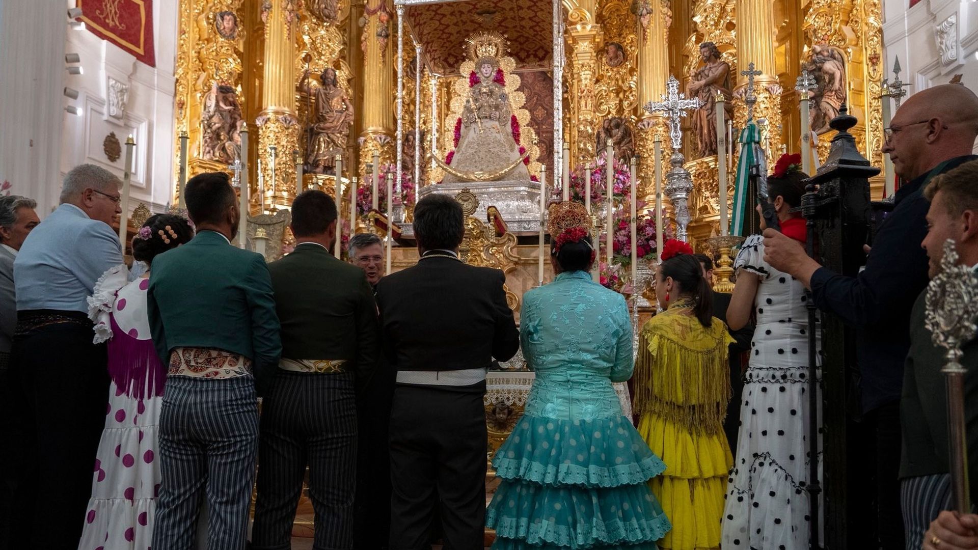 Varias personas frente a la Virgen del Rocío Varias personas frente a la Virgen del Rocío