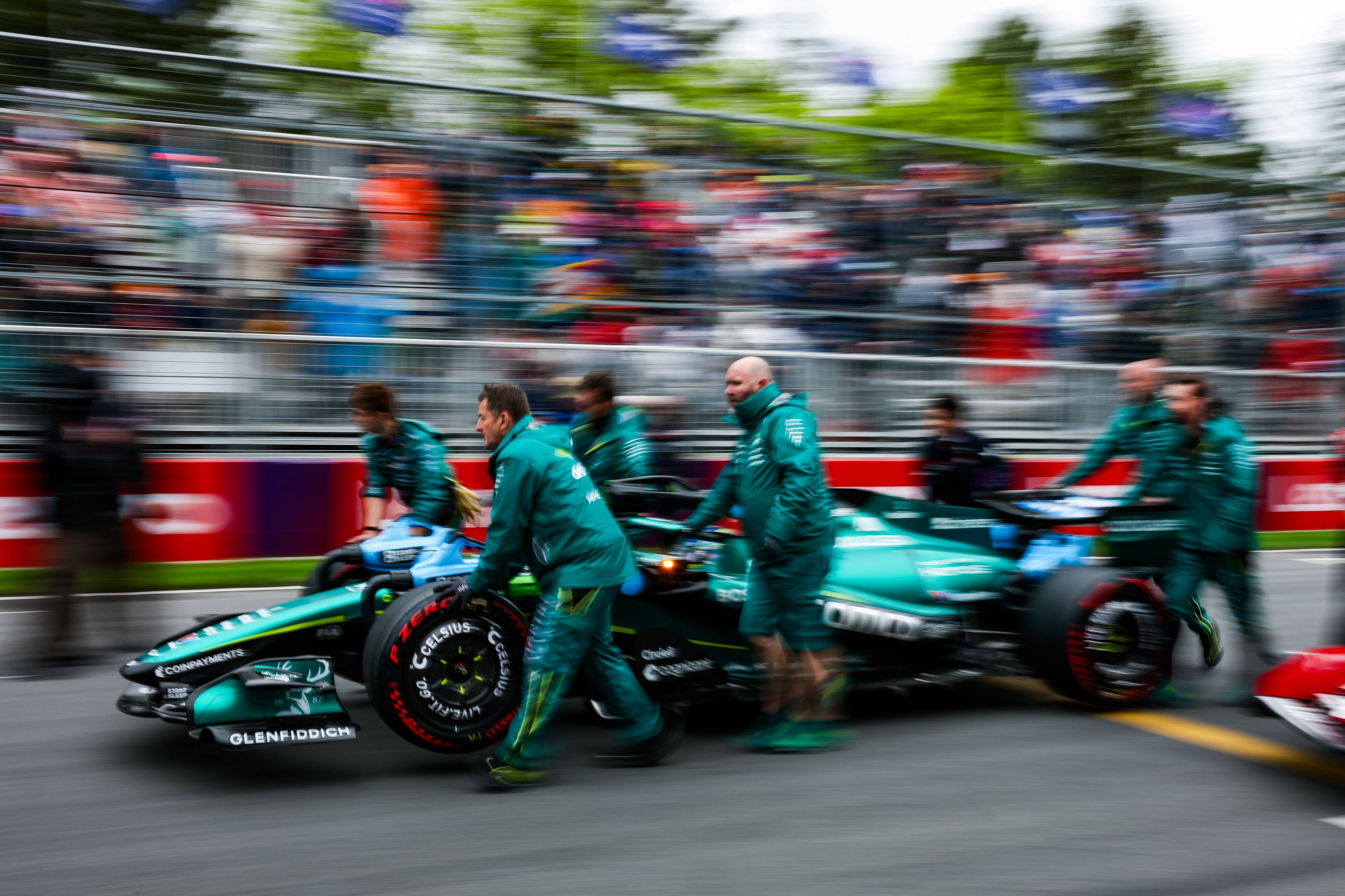 Los mecánicos de Aston Martin empujando el coche de Fernando Alonso