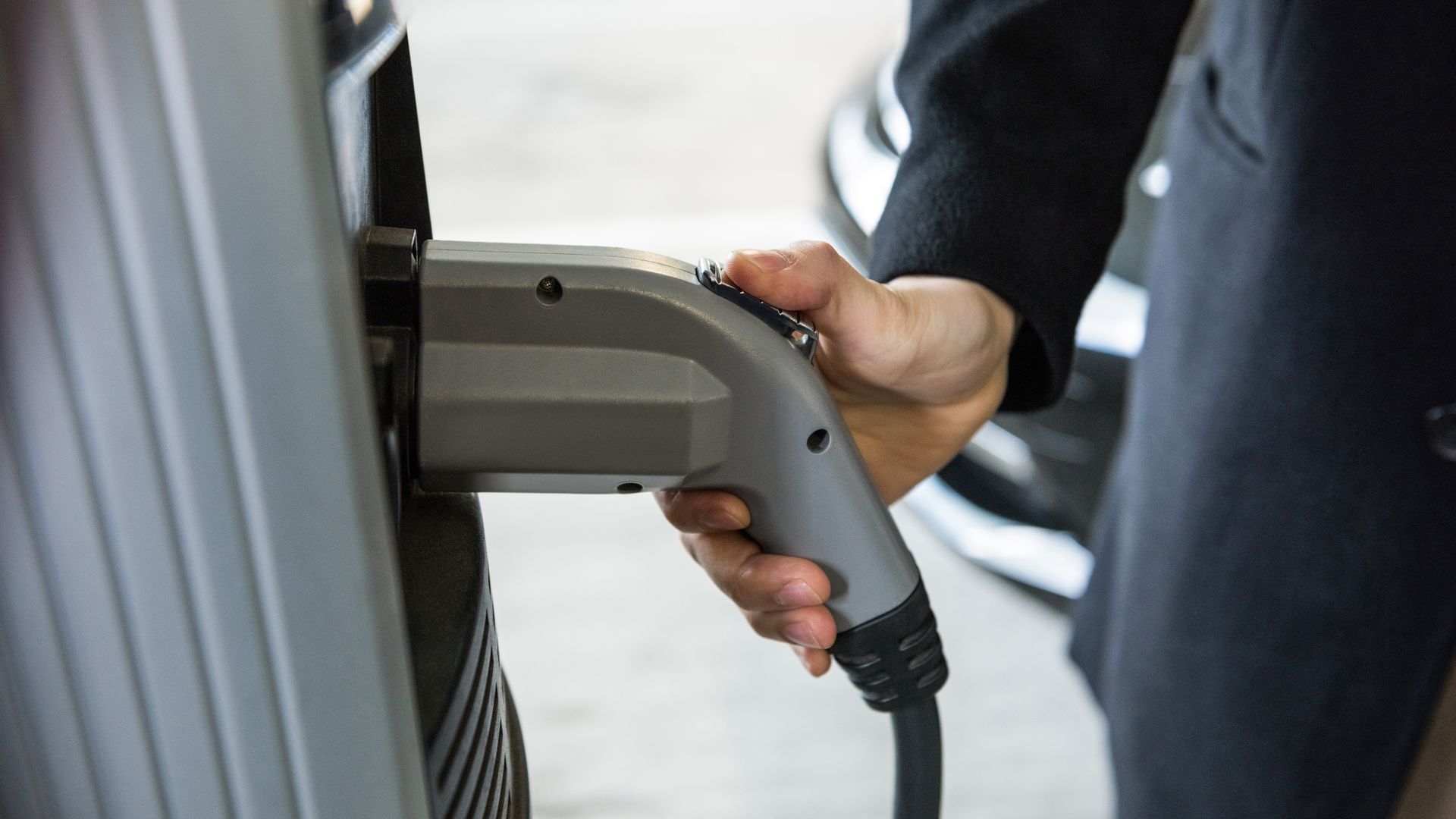 Hombre cargando el coche en la estación de carga de vehículos eléctricos Hombre cargando el coche en la estación de carga de vehículos eléctricos