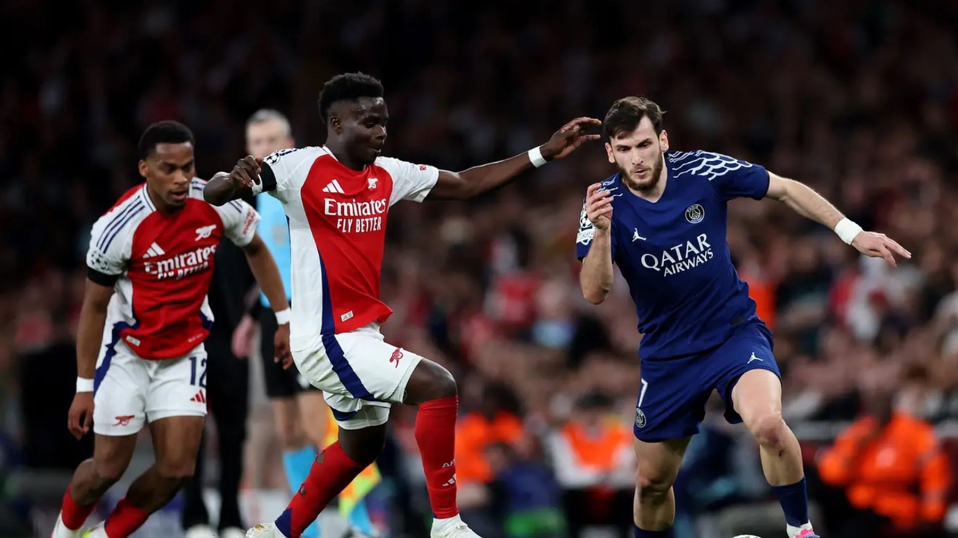 Kvaratskhelia corre delante de Bukayo Saka en el PSG-Arsenal de la 24/25