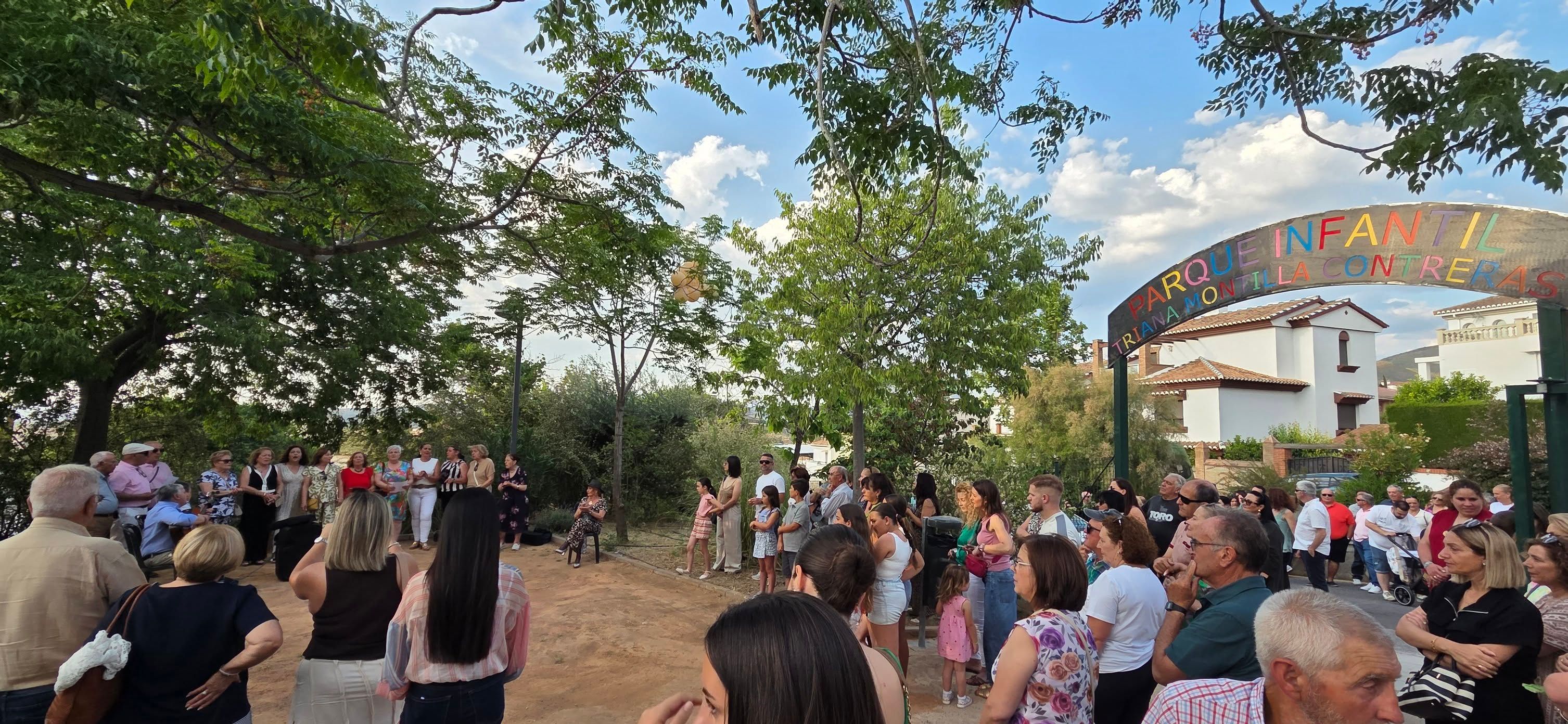 Vecinos y familia de Triana reunidos en el espacio de juegos infantiles