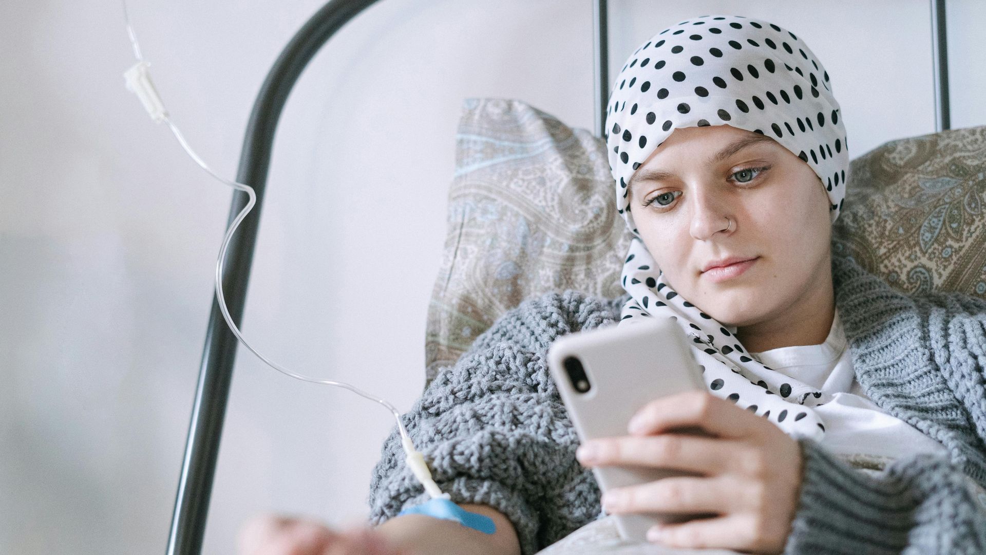 Una jóven con cáncer usando su móvil