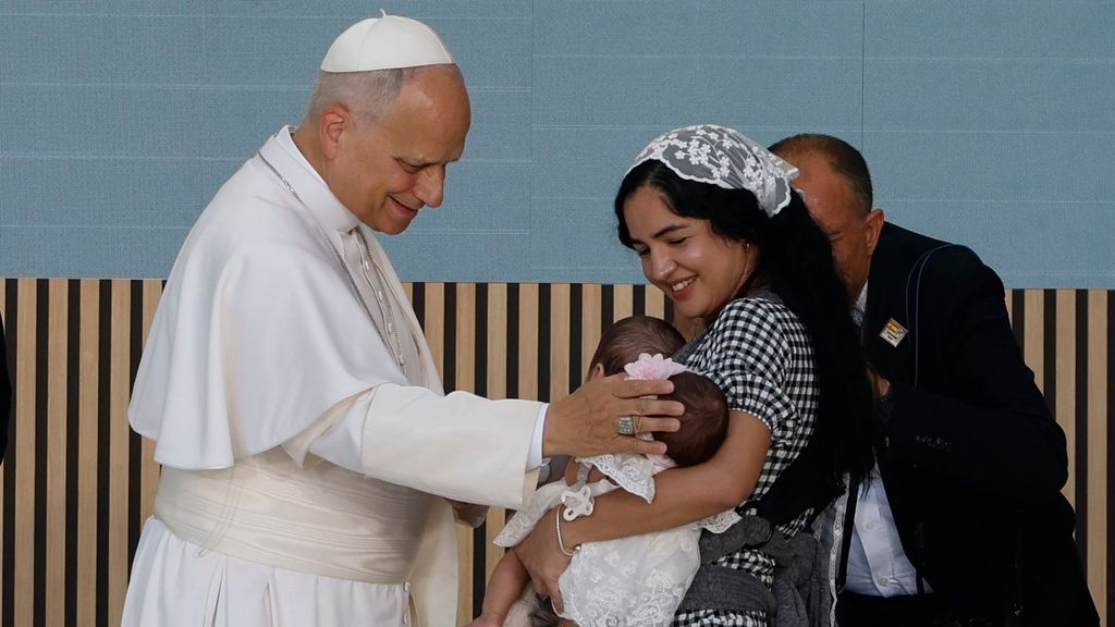 El papa da la bendición a los dos gemelos de una madre migrante
