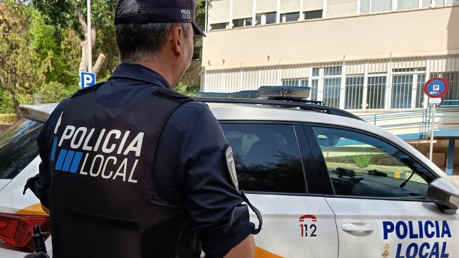 Archivo - Agente de la Policía Local de Palma frente a un coche patrulla. Archivo - Agente de la Policía Local de Palma frente a un coche patrulla.