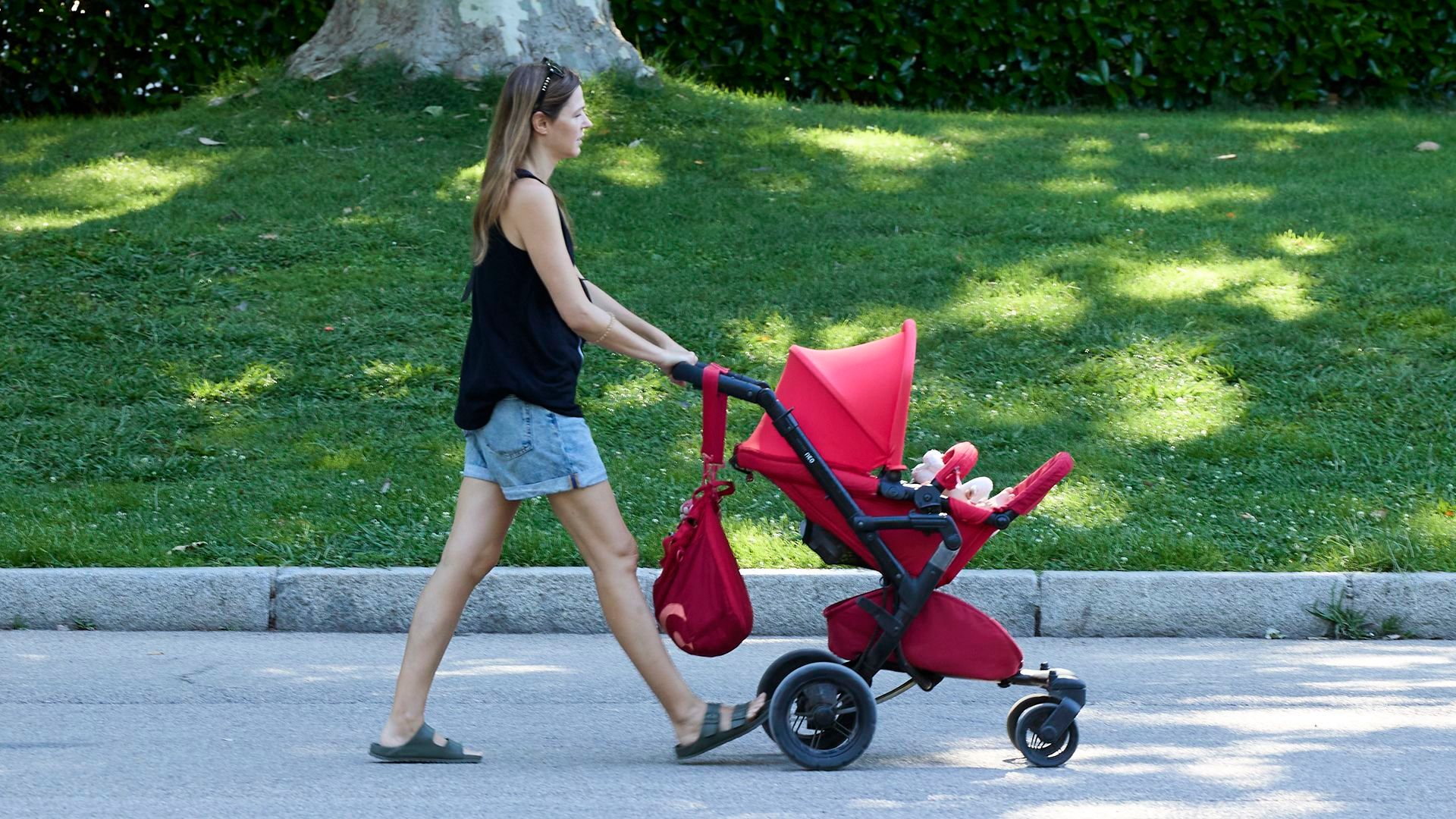 Una chica paseando un carrito por El Retiro Una chica paseando un carrito por El Retiro