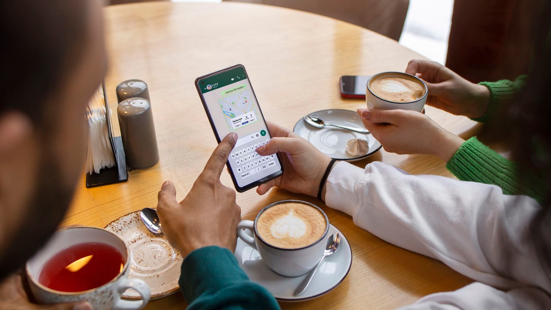 Unas personas mirando una conversación de WhatsApp en el móvil Unas personas mirando una conversación de WhatsApp en el móvil