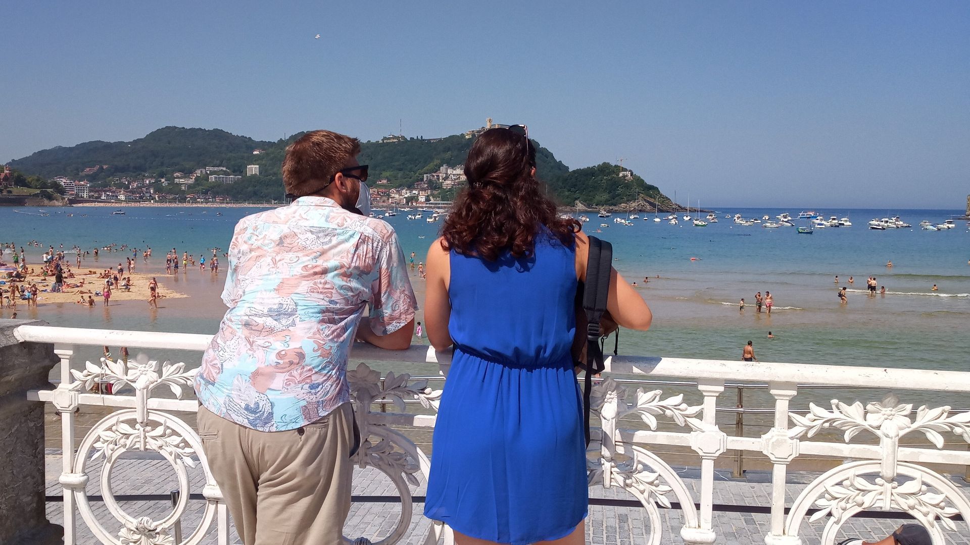 Una pareja de turistas contempla la playa donostiarra de La Concha desde el paseo Una pareja de turistas contempla la playa donostiarra de La Concha desde el paseo