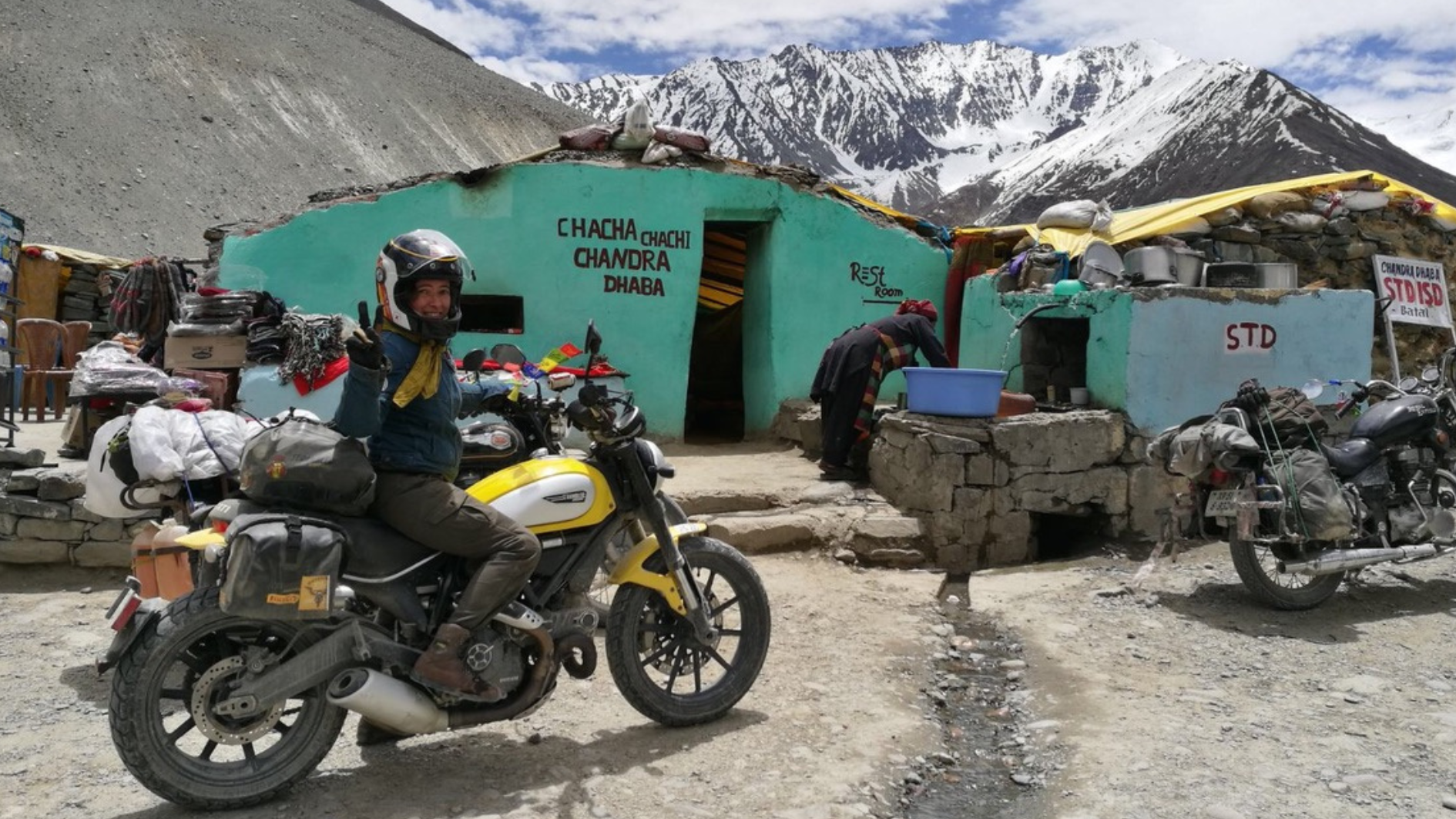 Alicia, sobre su moto y con un paisaje montañoso al fondo