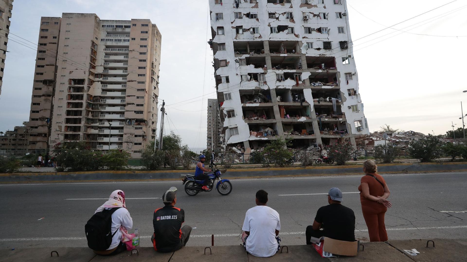 esidentes observan uno de los bloques de viviendas dañados por los terremotos