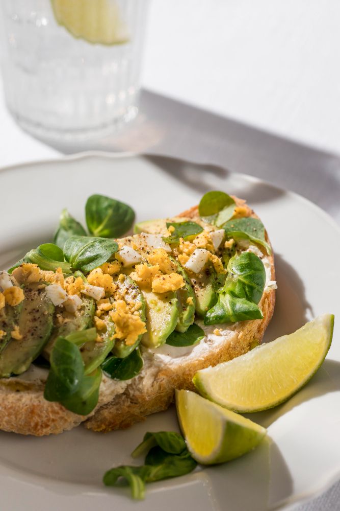 Tosta de aguacate, huevo, queso crema y un chorrito de limón