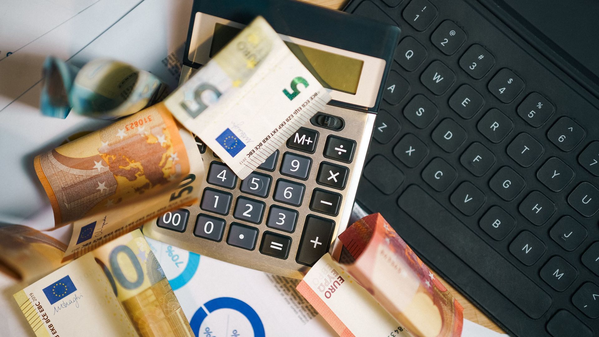 Distintos billetes de euro sobre una calculadora y un ordenador Distintos billetes de euro sobre una calculadora y un ordenador
