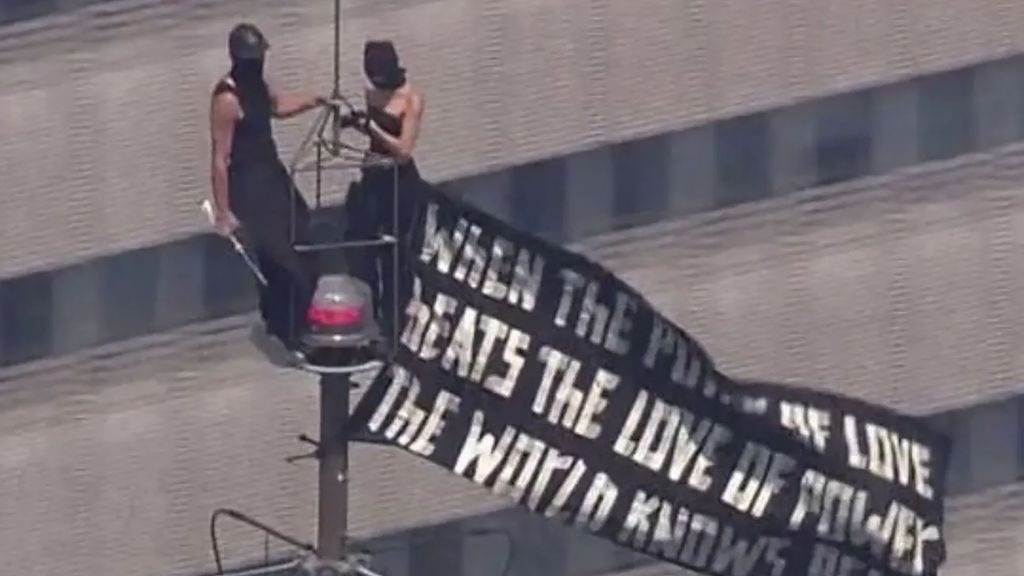 Dos personas escalan el Empire State de Nueva York y despliegan una pancarta en protesta por la paz