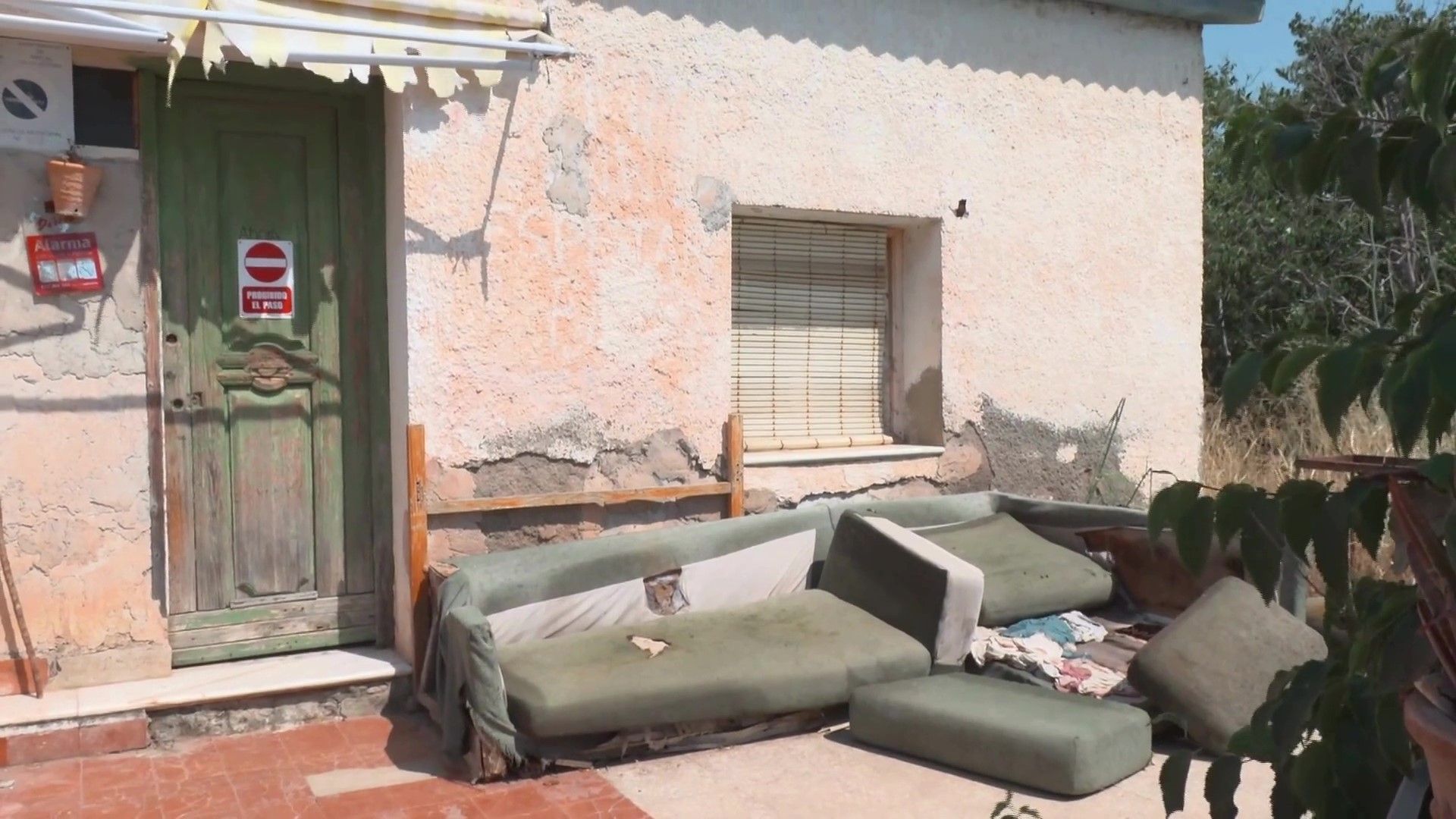 Sofas apilados en la puerta de la casa abandonada