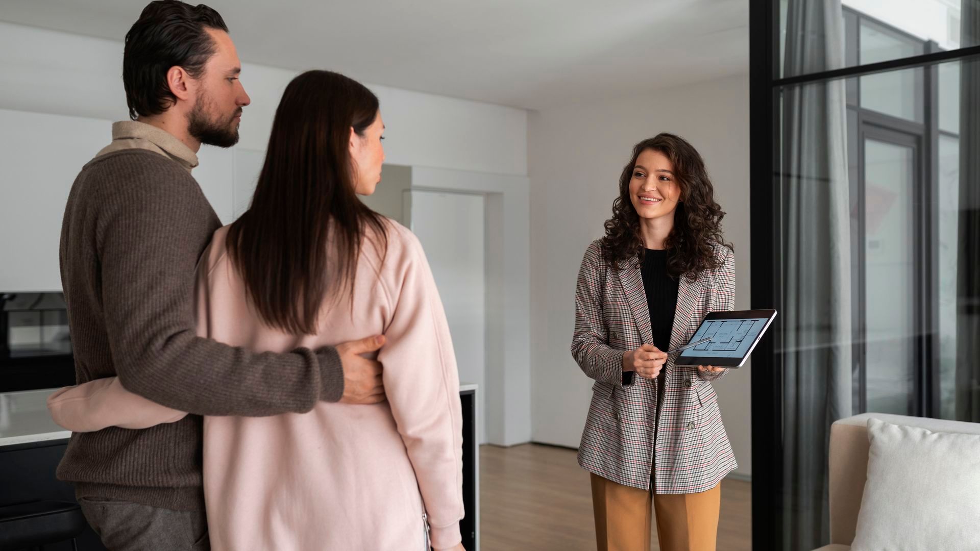 Una mujer enseñando una casa a una pareja Una mujer enseñando una casa a una pareja