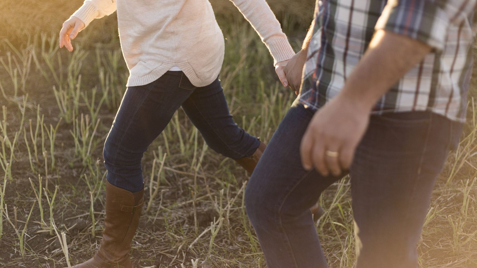 Una pareja camina por el campo cogida de la mano Una pareja camina por el campo cogida de la mano