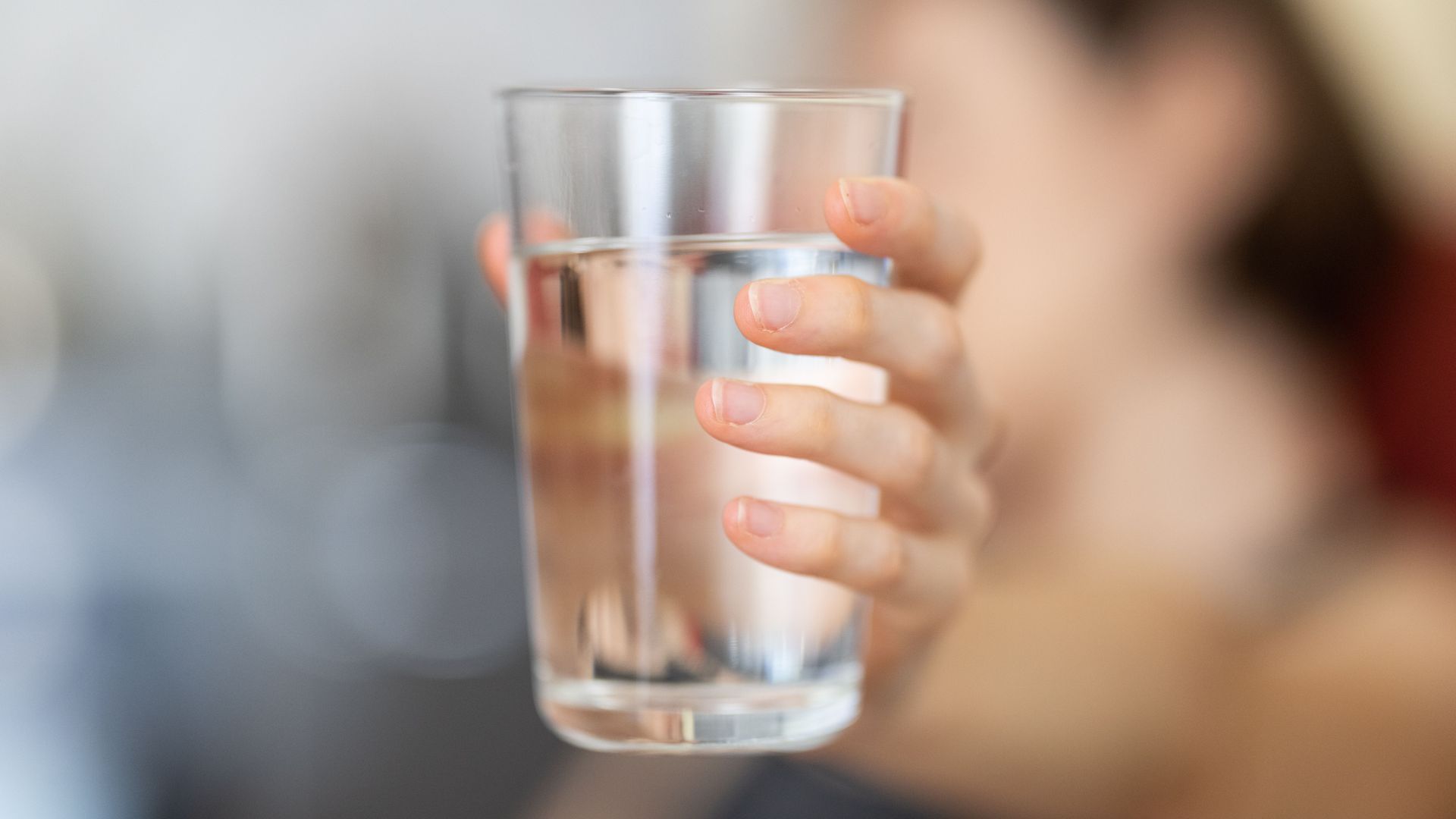 Foto de archivo de una chica sosteniendo un vaso de agua