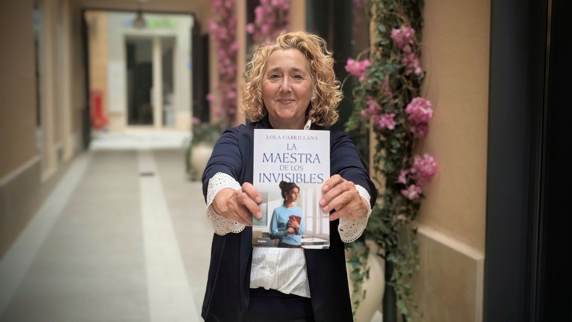 Lola Cabrillana, con una de sus novelas, 'La maestra de los invisibles' Lola Cabrillana, con una de sus novelas, 'La maestra de los invisibles'
