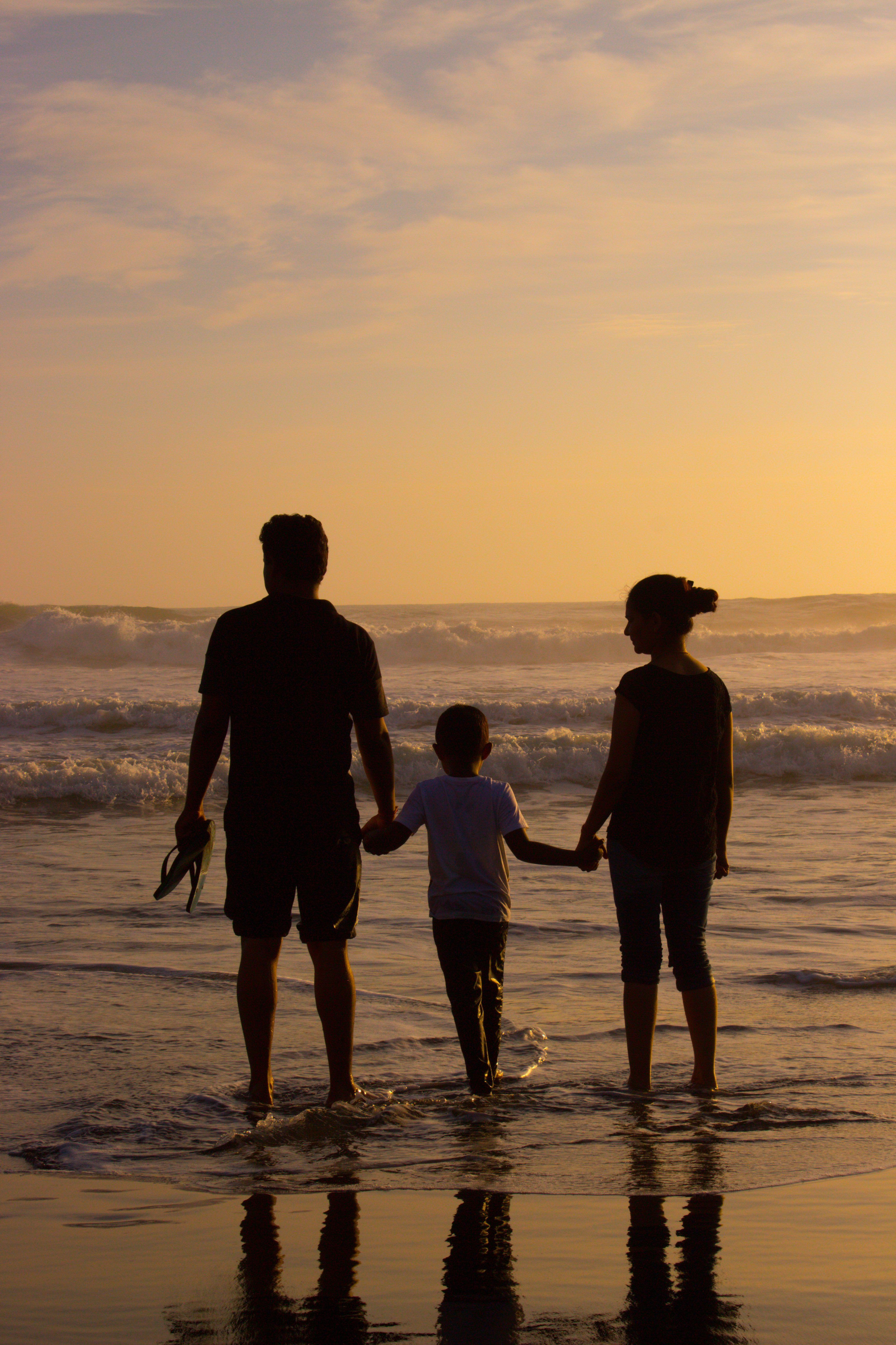Una familia paseando por la playa al atardecer