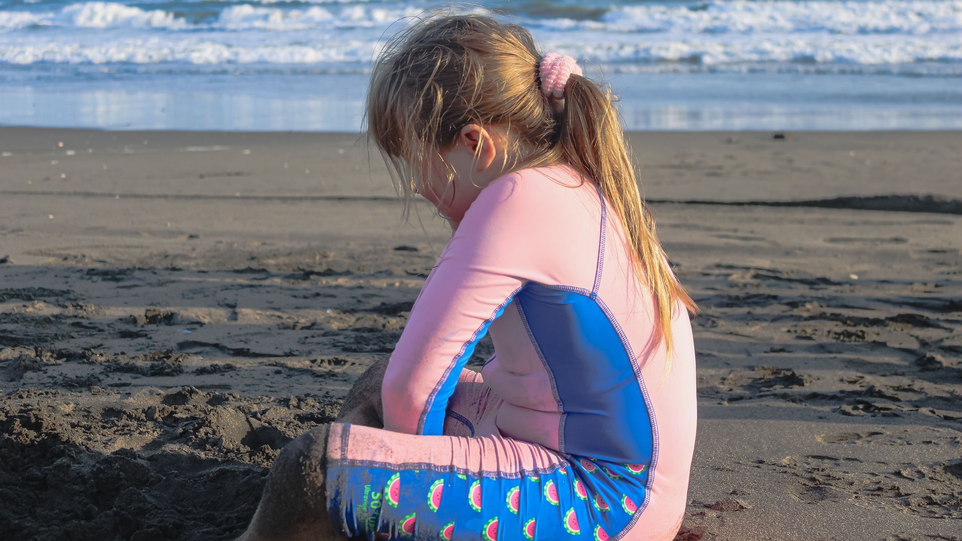 Una niña con un traje de baño de nailon en la playa Una niña con un traje de baño de nailon en la playa