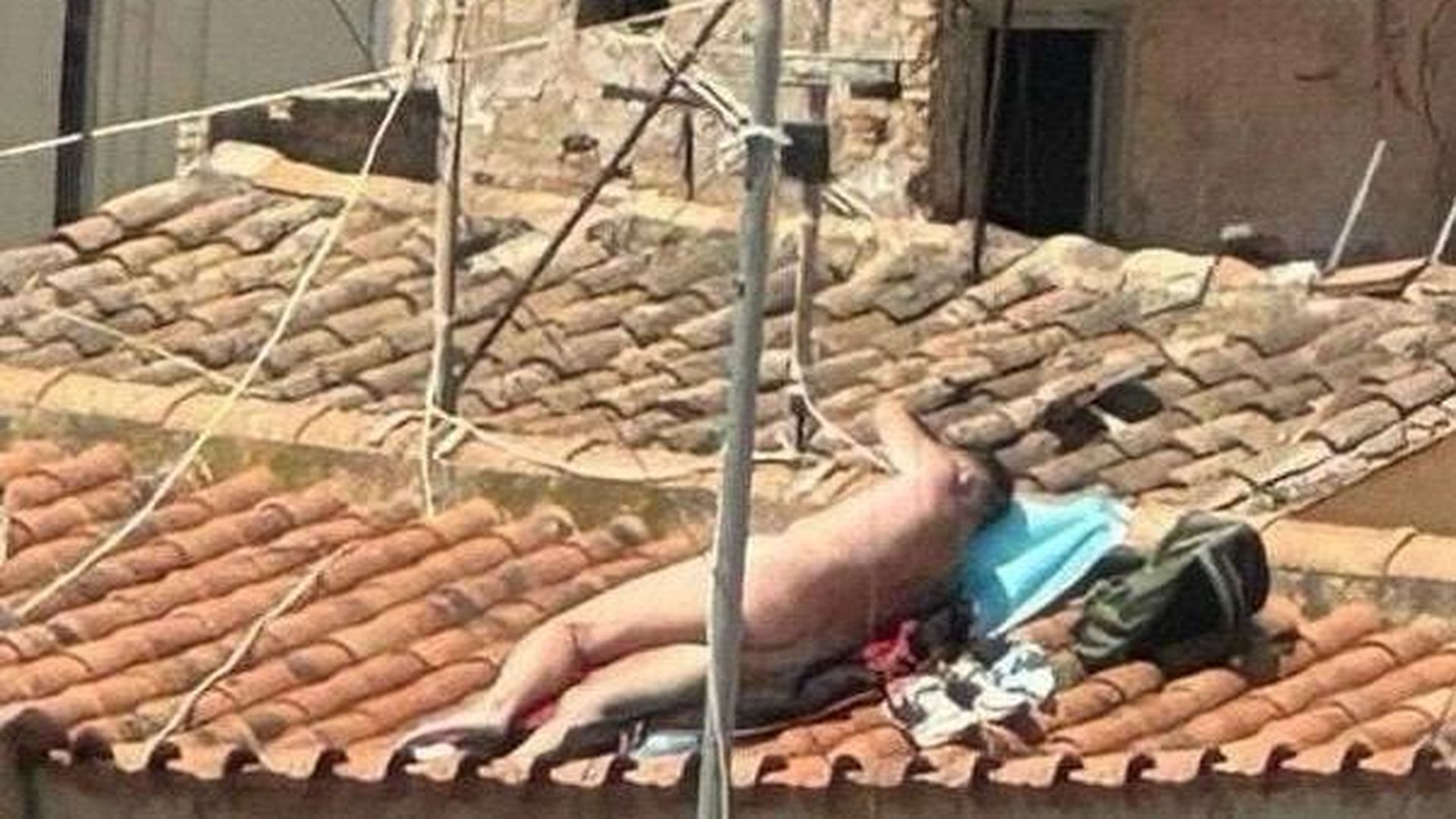 Un turista toma el sol desnudo en el tejado de su apartamento