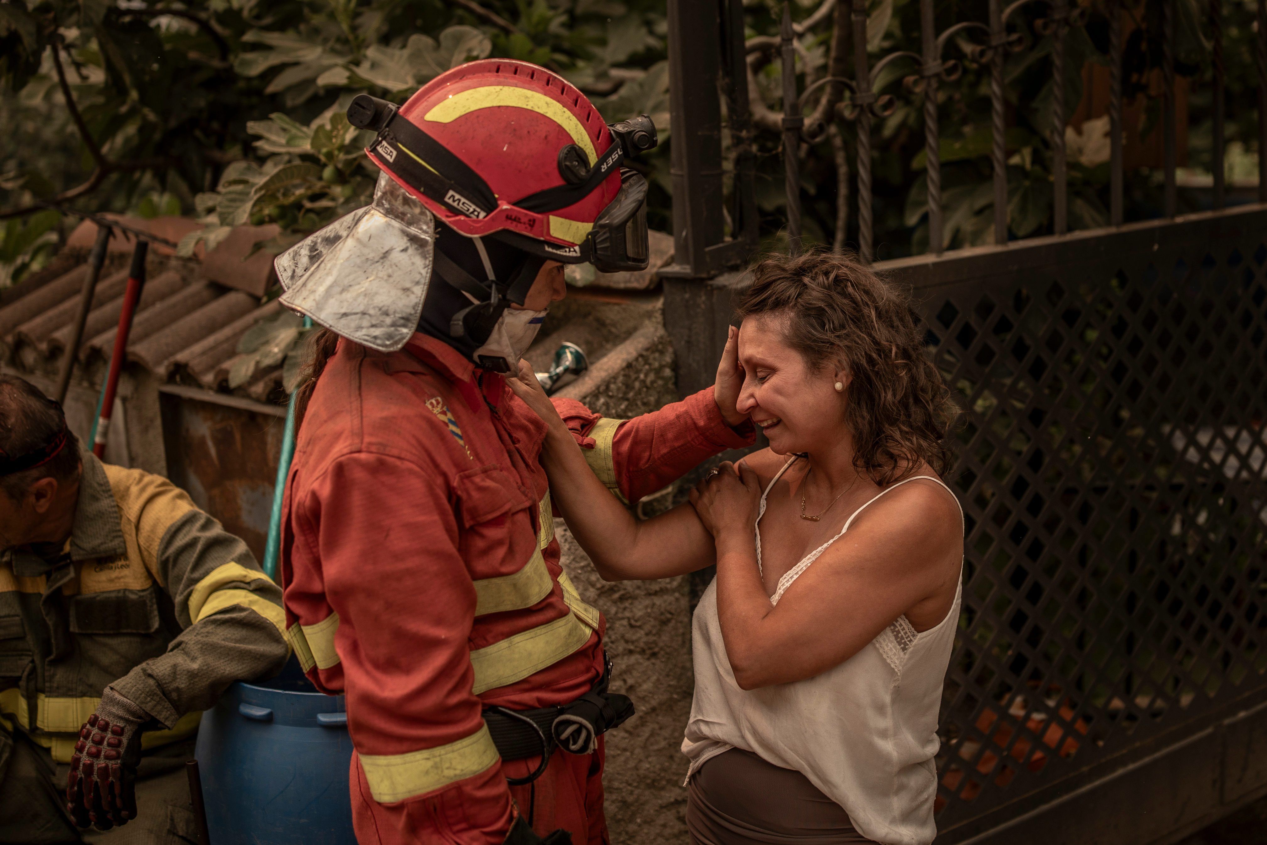 Un bombero trata de calmar a una de las afectadas en el incendio que se declaró en el valle del Tiétar