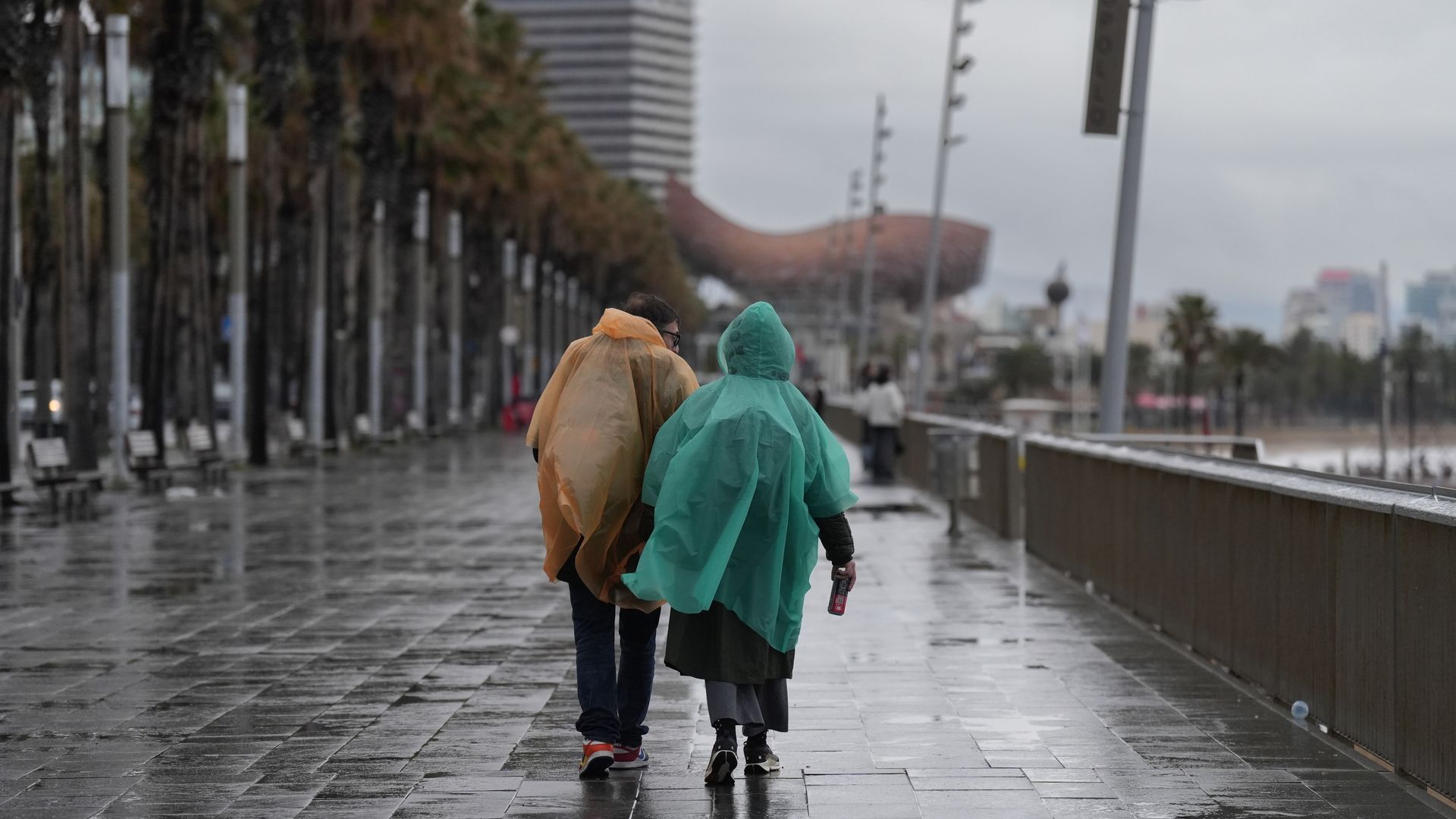Dos viandantes pasean por Barcelona bajo la lluvia Dos viandantes pasean por Barcelona bajo la lluvia