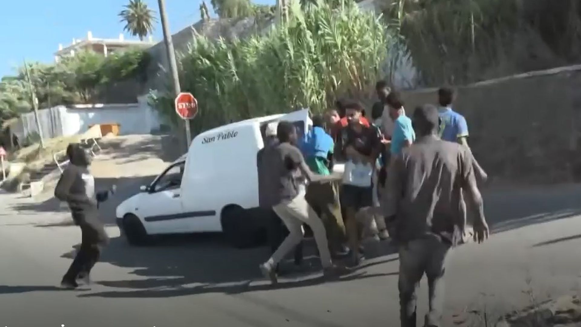 Inmigrantes corren hacia una furgoneta con comida de una ONG en Ceuta