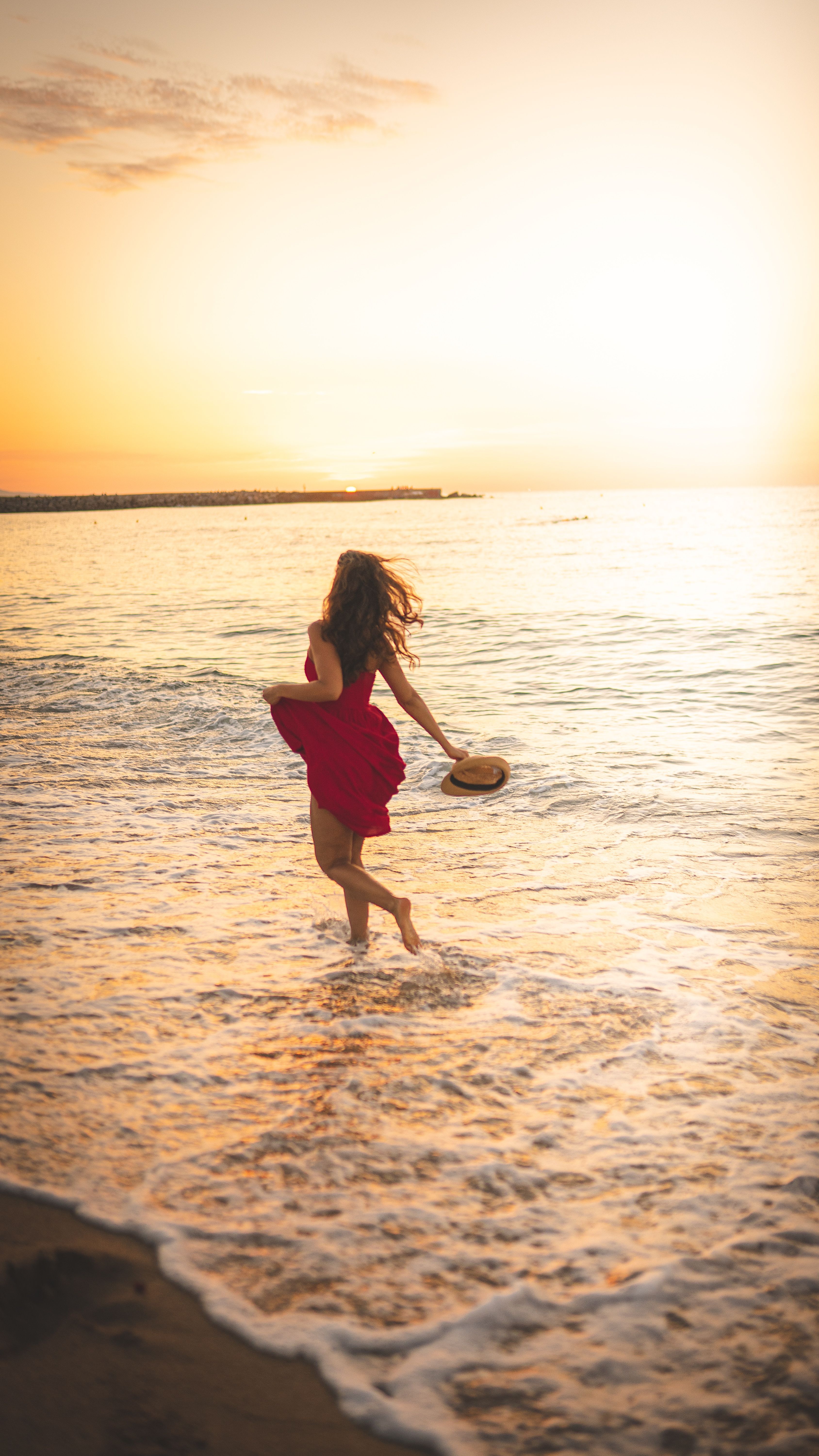 Mujer paseando por la orilla de la playa