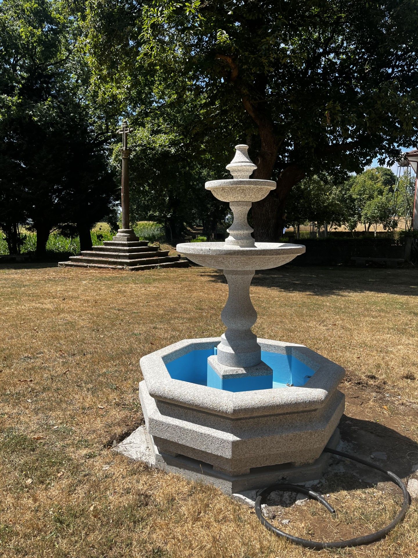 Imagen de la fuente aun pintada de azul instalada a pocos metros de un crucero catalogado
