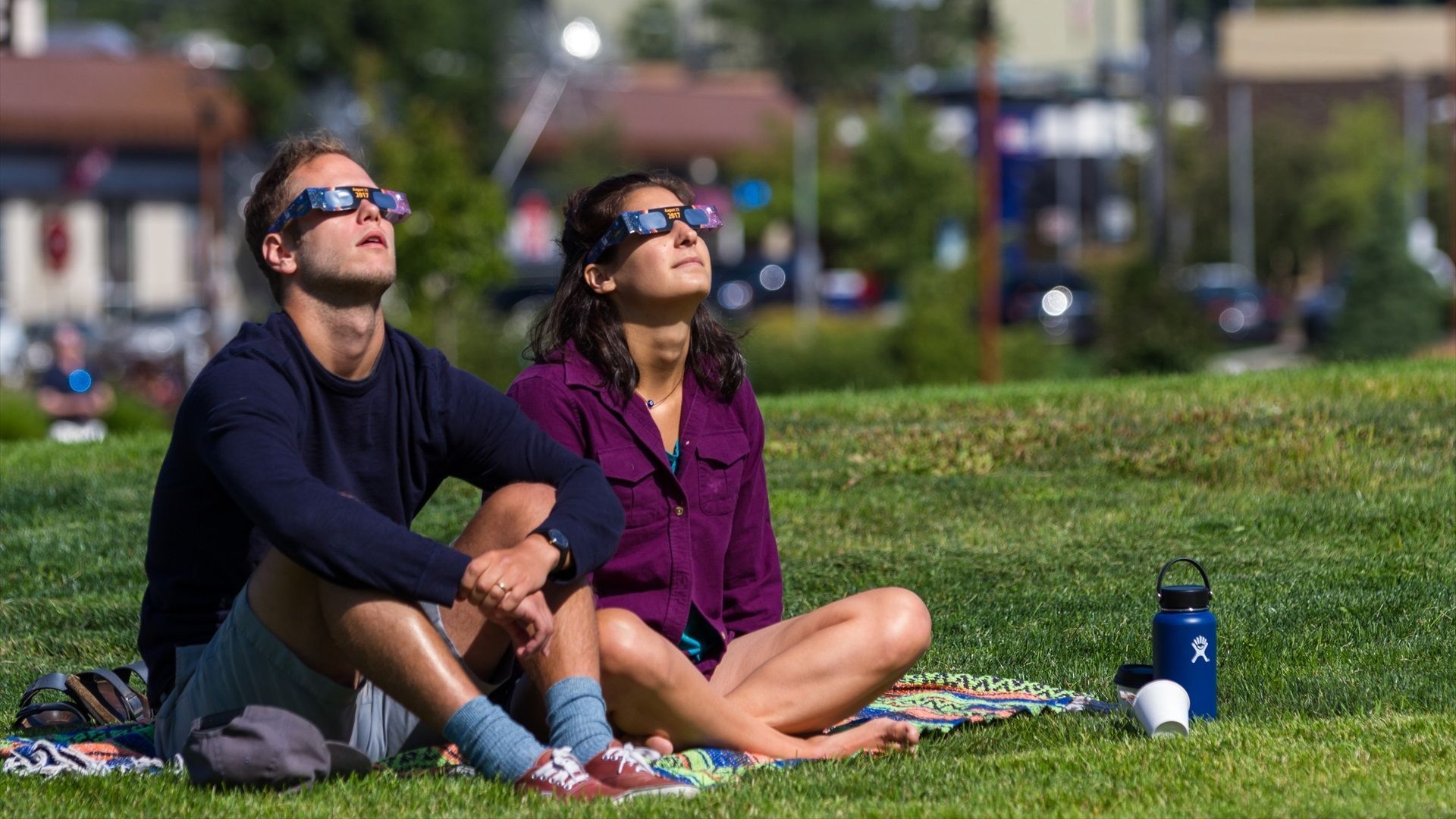 Dos personas miran al cielo con gafas homologadas Dos personas miran al cielo con gafas homologadas