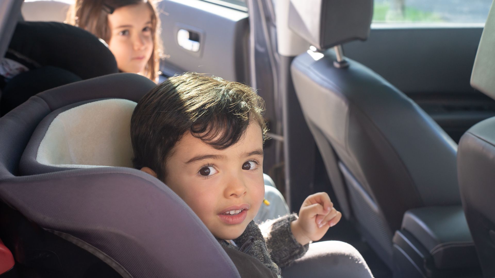 Niños sentados en el asiento trasero del coche