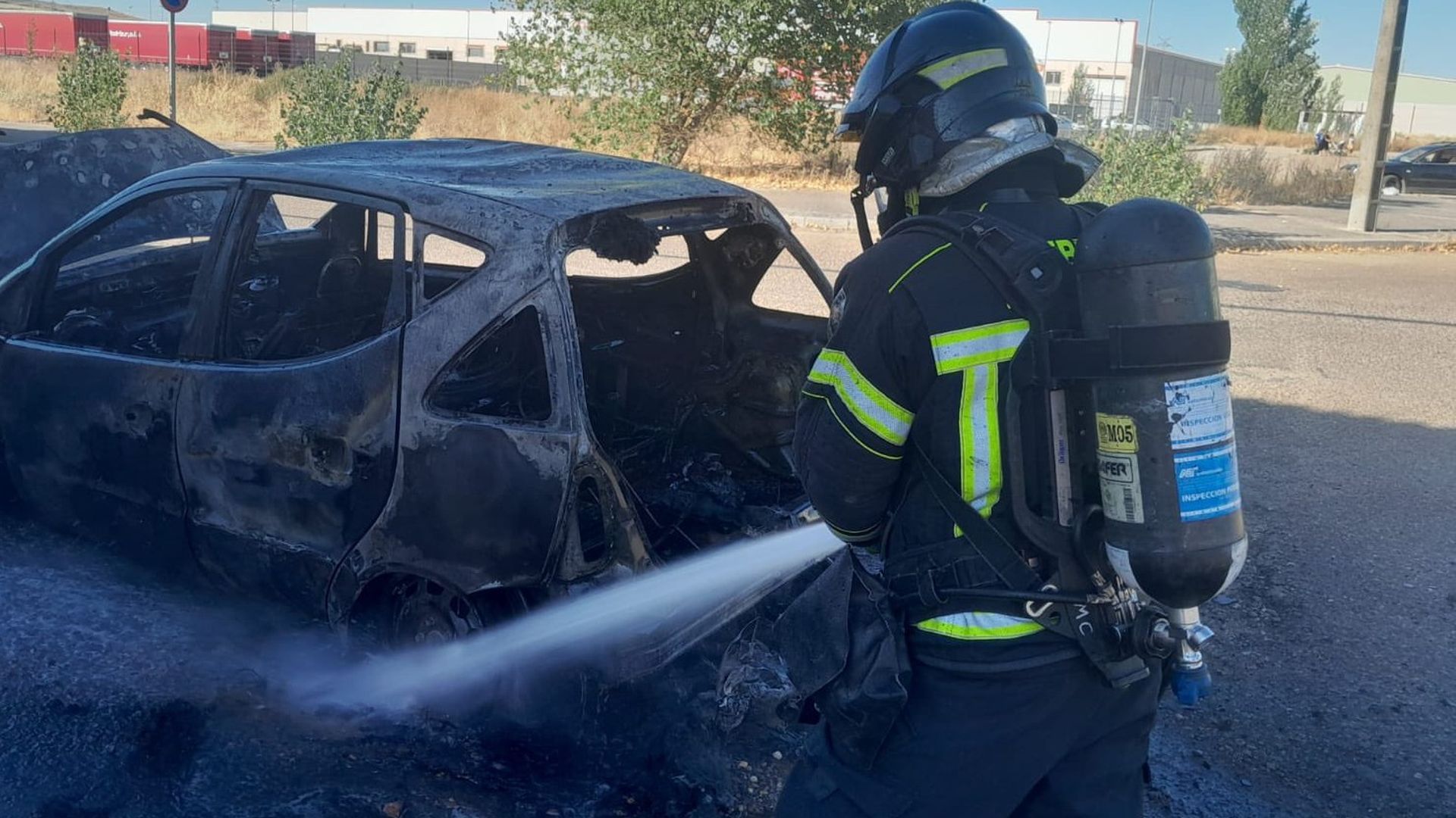 Bombero apaga un incendio en un coche Bombero apaga un incendio en un coche