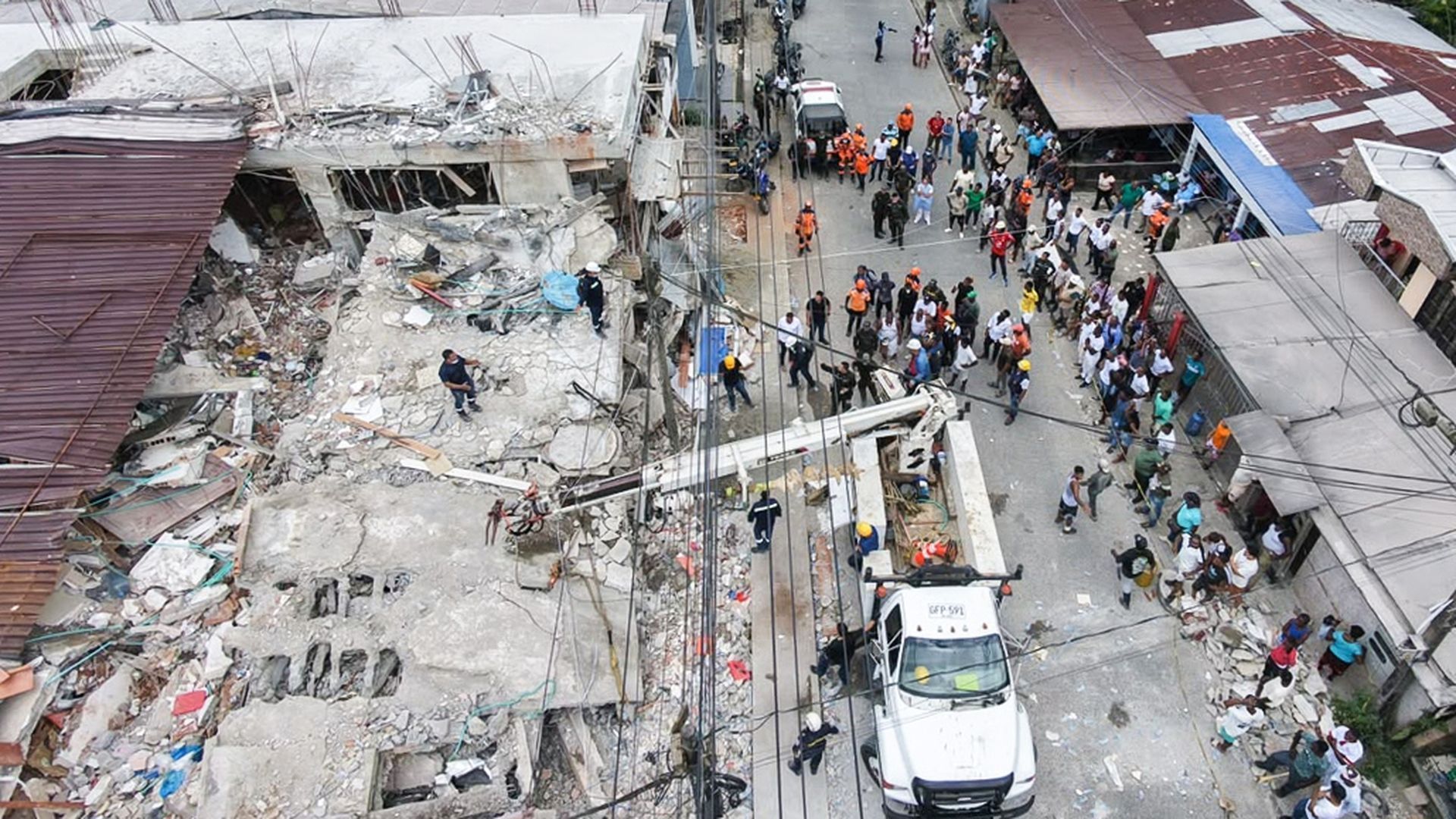 Fotografía aérea que muestra a civiles buscando entre los escombros de un edificio destruido por el terremoto de magnitud 7,4
