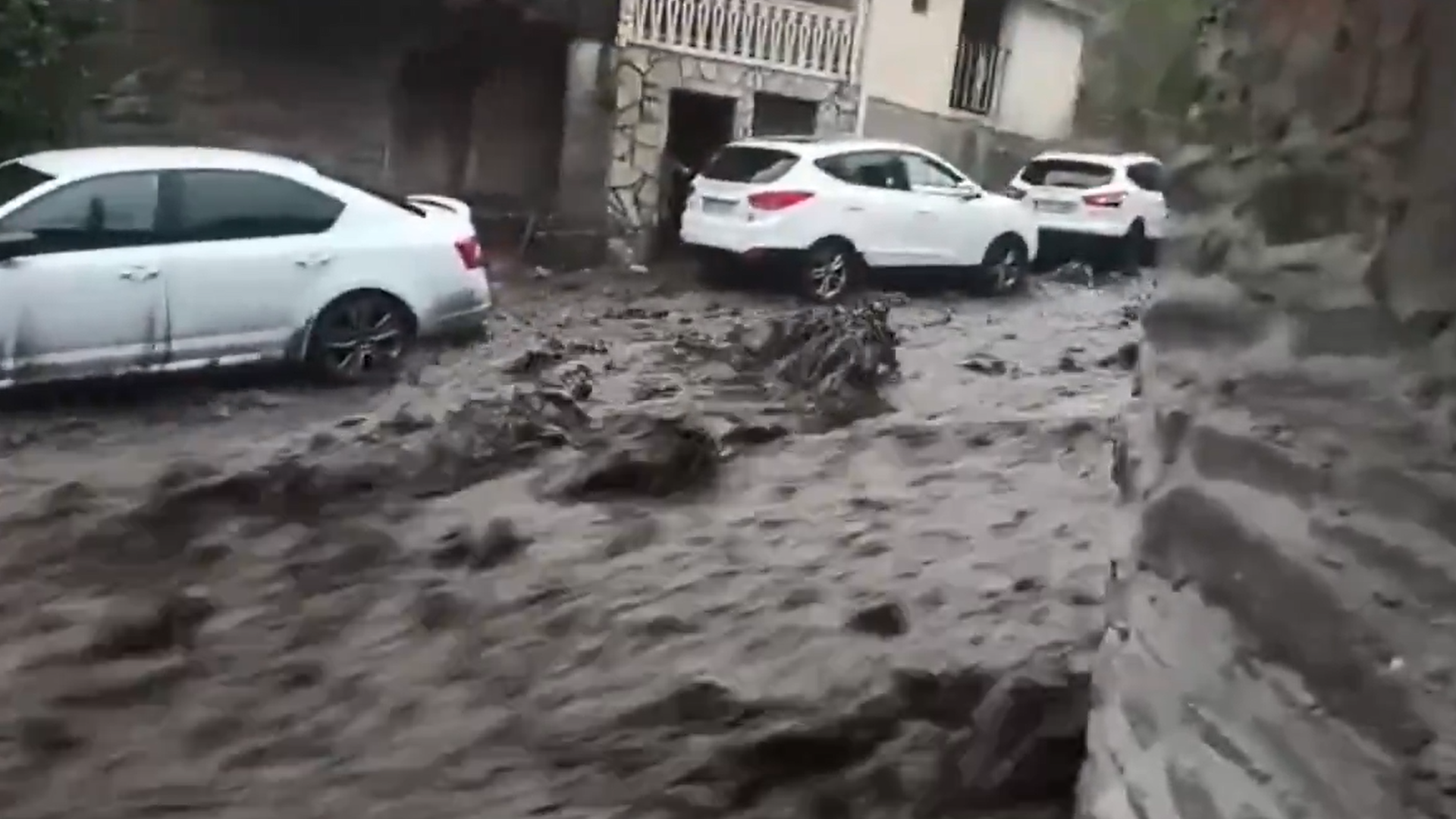 Agua embarrada bajando con fuerza por una calle de Manzanedo de Valdueza, León