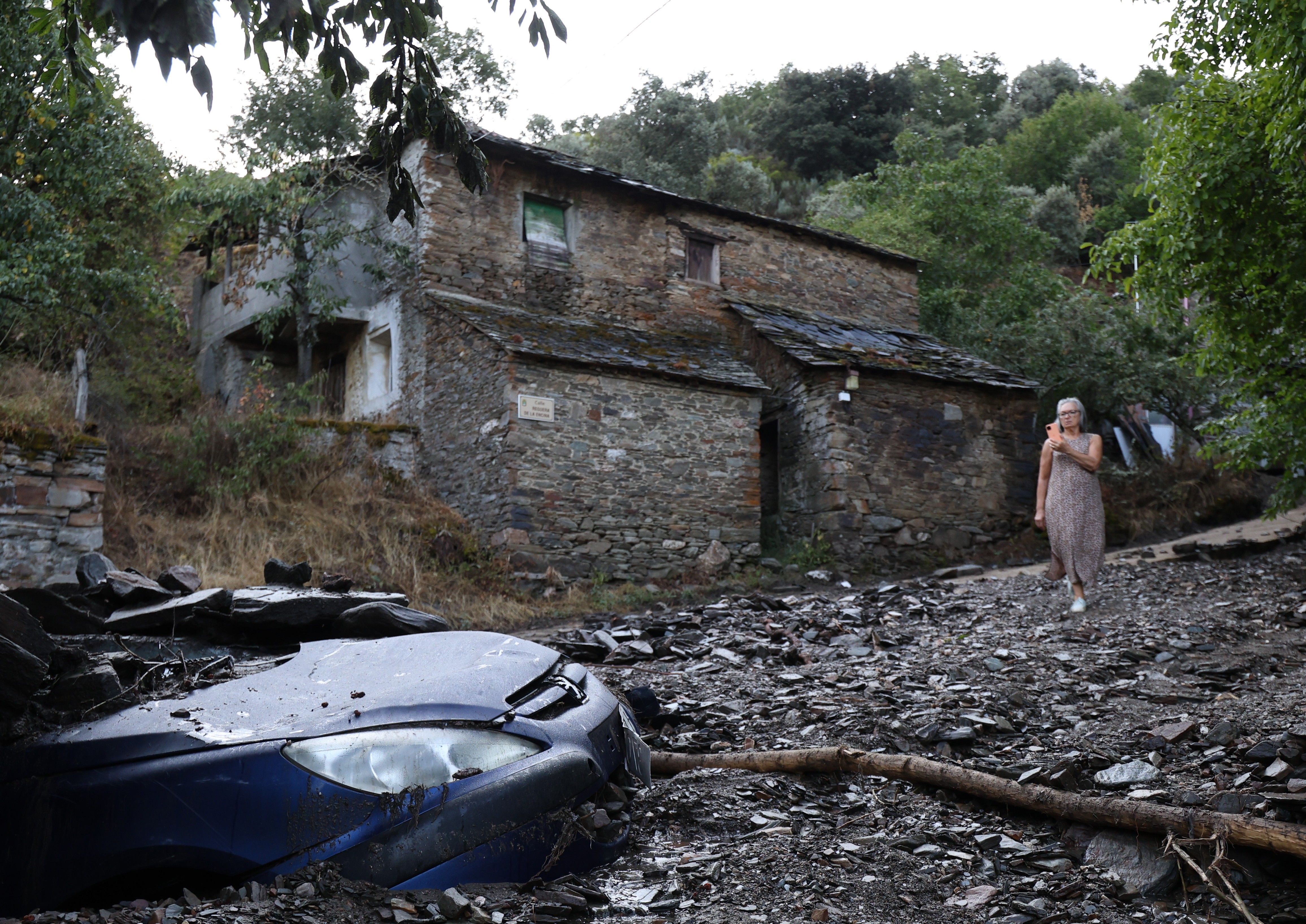 Coche casi sepultado en Manzaneda y una vecina captándolo con su móvil
