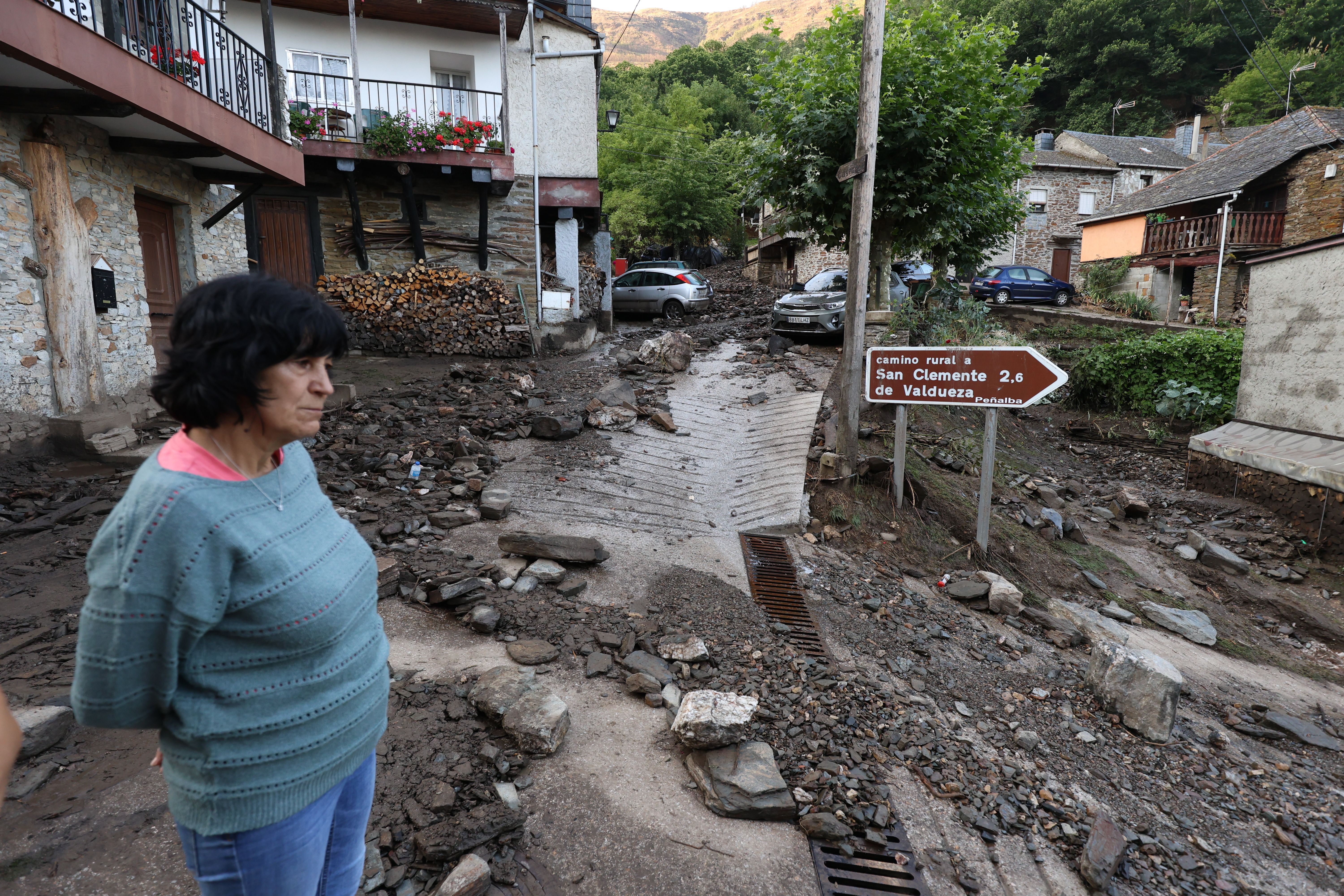Una vecina observa la escena desoladora del pueblo embarrado
