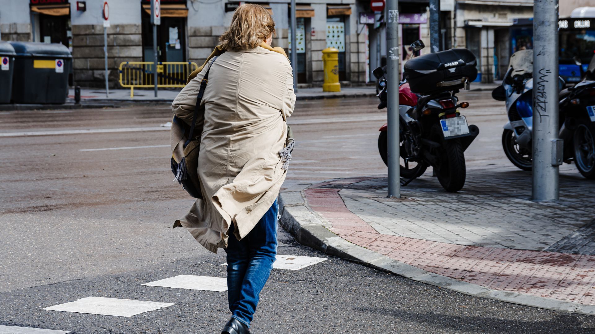 Una persona cruza por un paso de peatones en una ciudad Una persona cruza por un paso de peatones en una ciudad