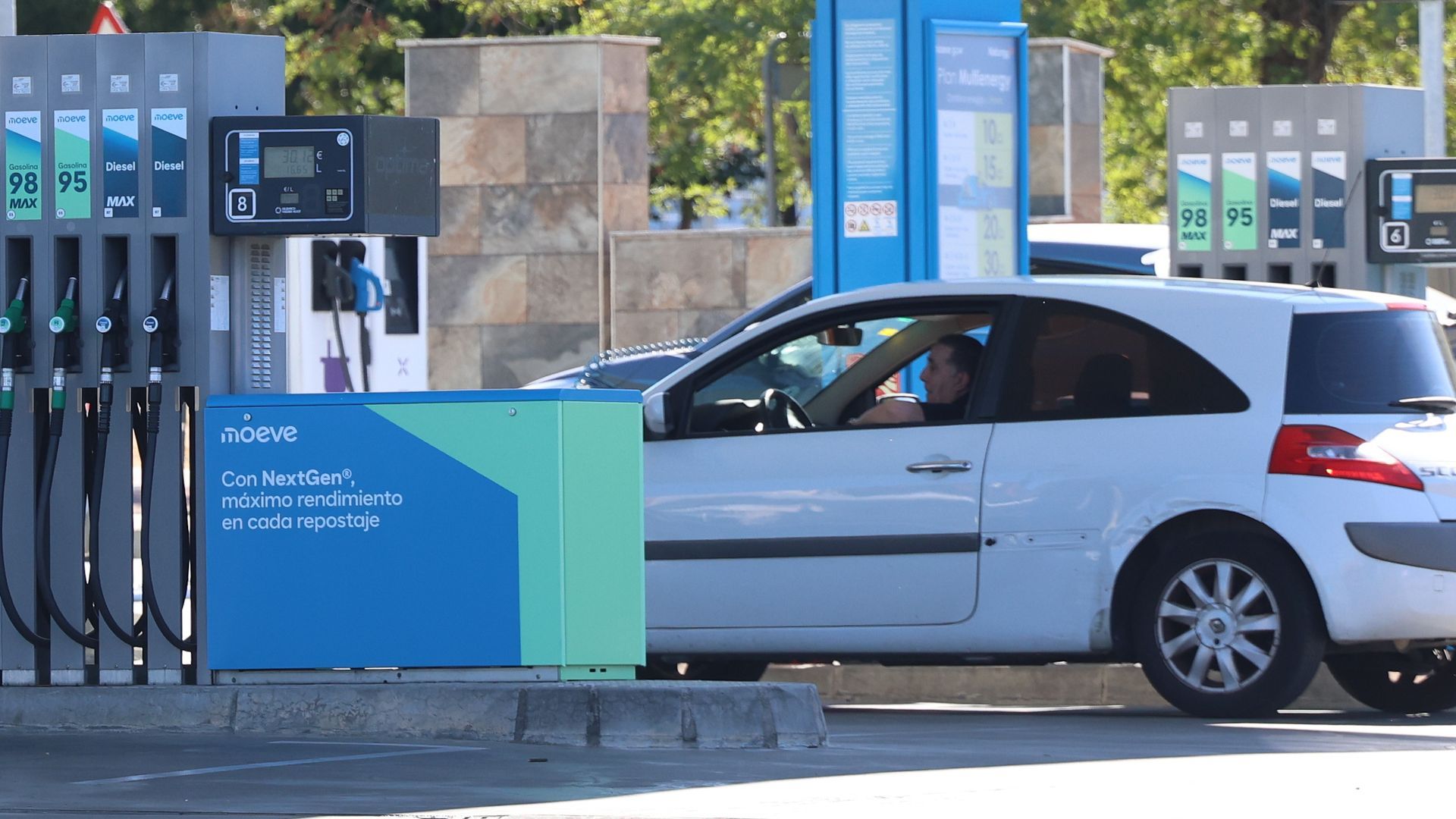 Un coche repostando en una gasolinera Un coche repostando en una gasolinera